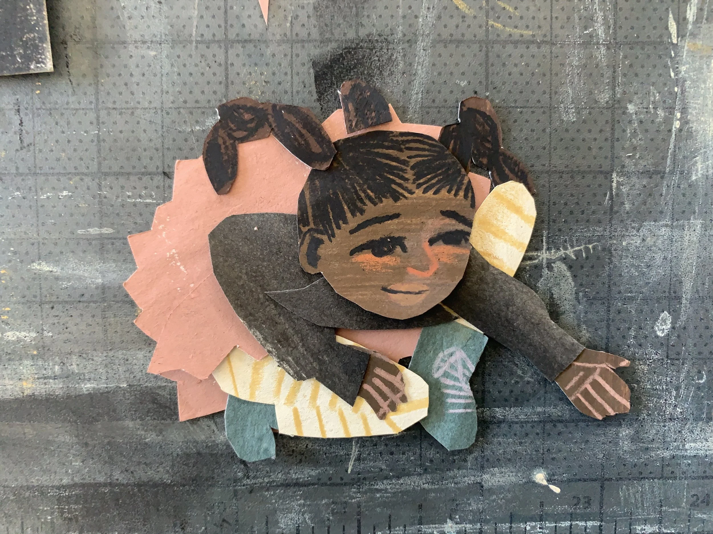 a little black girl made of paper leans forward, hand outstretched.