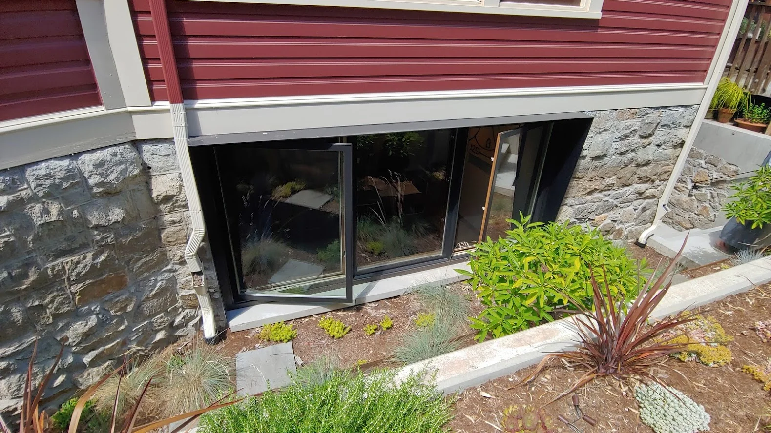 This basement apartment spared no expense with the large windows and additional landscaping - Designer: GustoDesignStudio.com