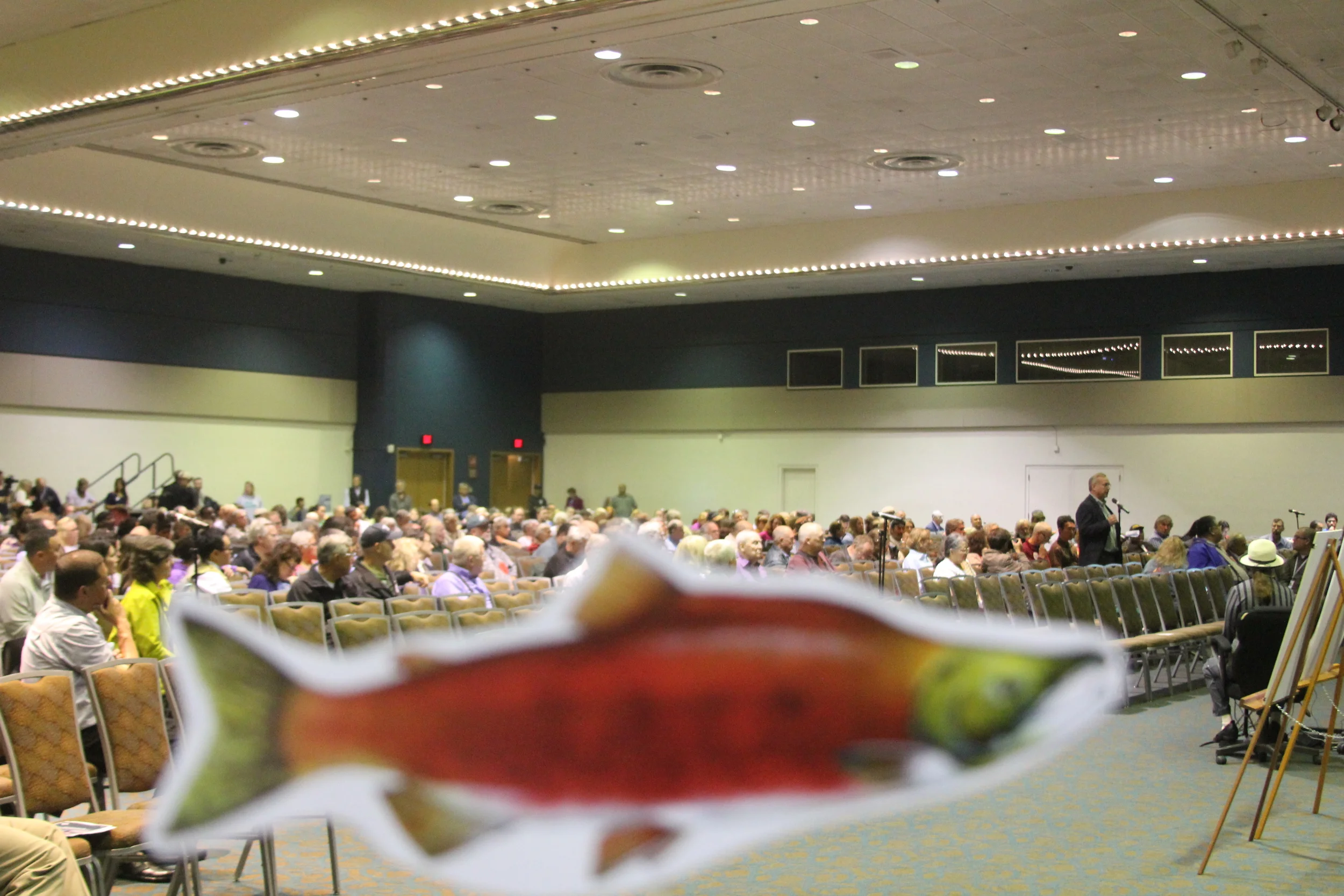 Save Bristol Bay supporters waved salmon signs during testimony to the EPA