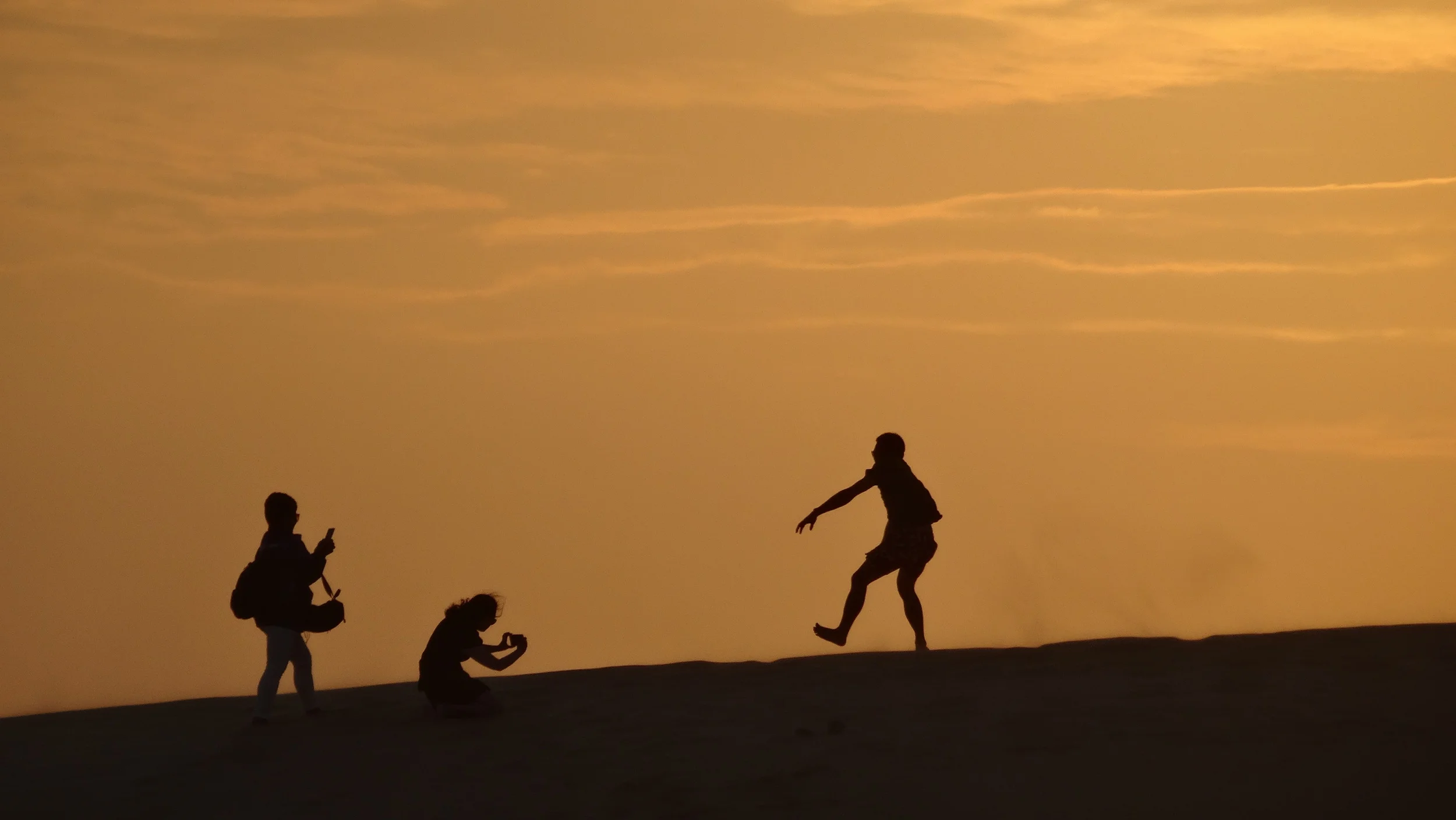 Tourists trying to get the perfect "jumping" shot with the sunset. 