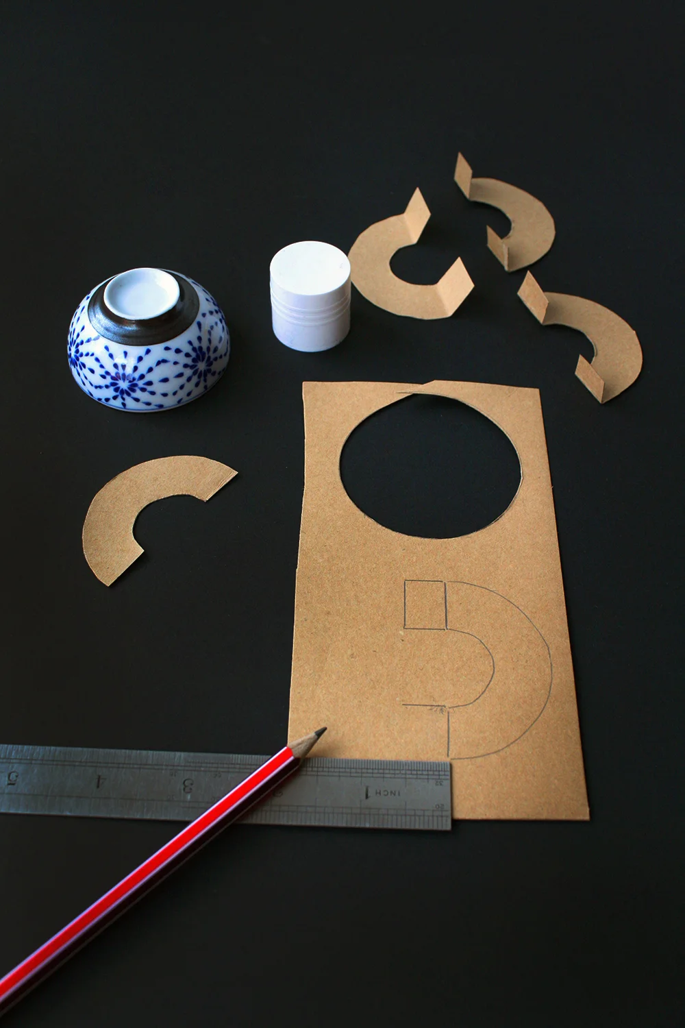 Step 1 If you have a pom pom maker, skip ahead to Step 2. If not, here's how to make one using a small bowl or other circle shape (around 6cm in diameter) and the cap of a glue stick. Trace around the bowl onto card stock, cut it out, then place the cap in the middle of the circle and trace around that. Fold the circle in half and cut along the centre line to create 2 semi-circles. Cut around the inside circle line of one of the semi-circles to create an arch. Trace the arch onto card stock and add a 1.5cm tab onto the end of each. Cut this new shape out and fold the tabs up. You will need four of these shapes in total.