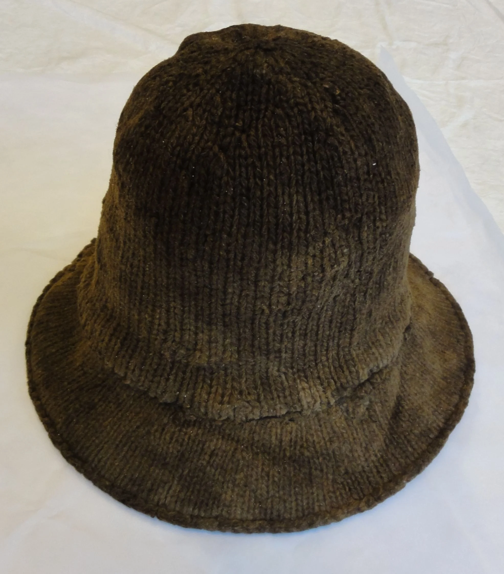 This image shows the unique bind-off edge at the outer perimeter of the brim. It is not a purl-ridge turned edge as so many reenactors use. Also, it is clear that the brim and the crown are knit in two different gauges.
