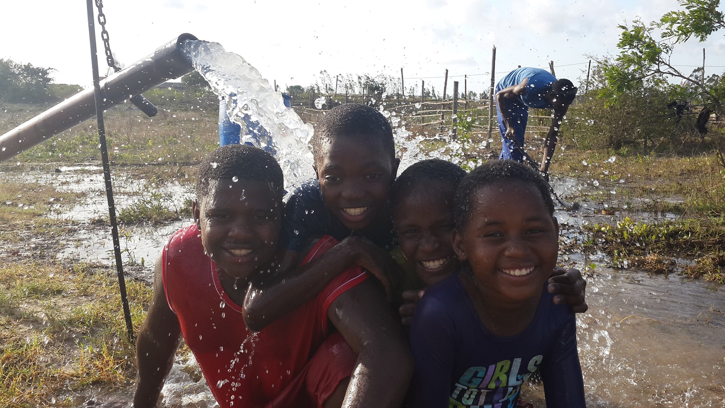 Children enjoy the novelty of pumped groundwater for the first time