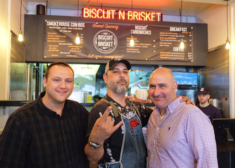 The owners and Nestor Laracuente (center) pose during the grand opening of Biscuit N Brisket back in May.