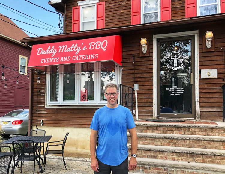 Matt "Matty" James takes a quick break from smoking out back to pose in front of his restaurant.