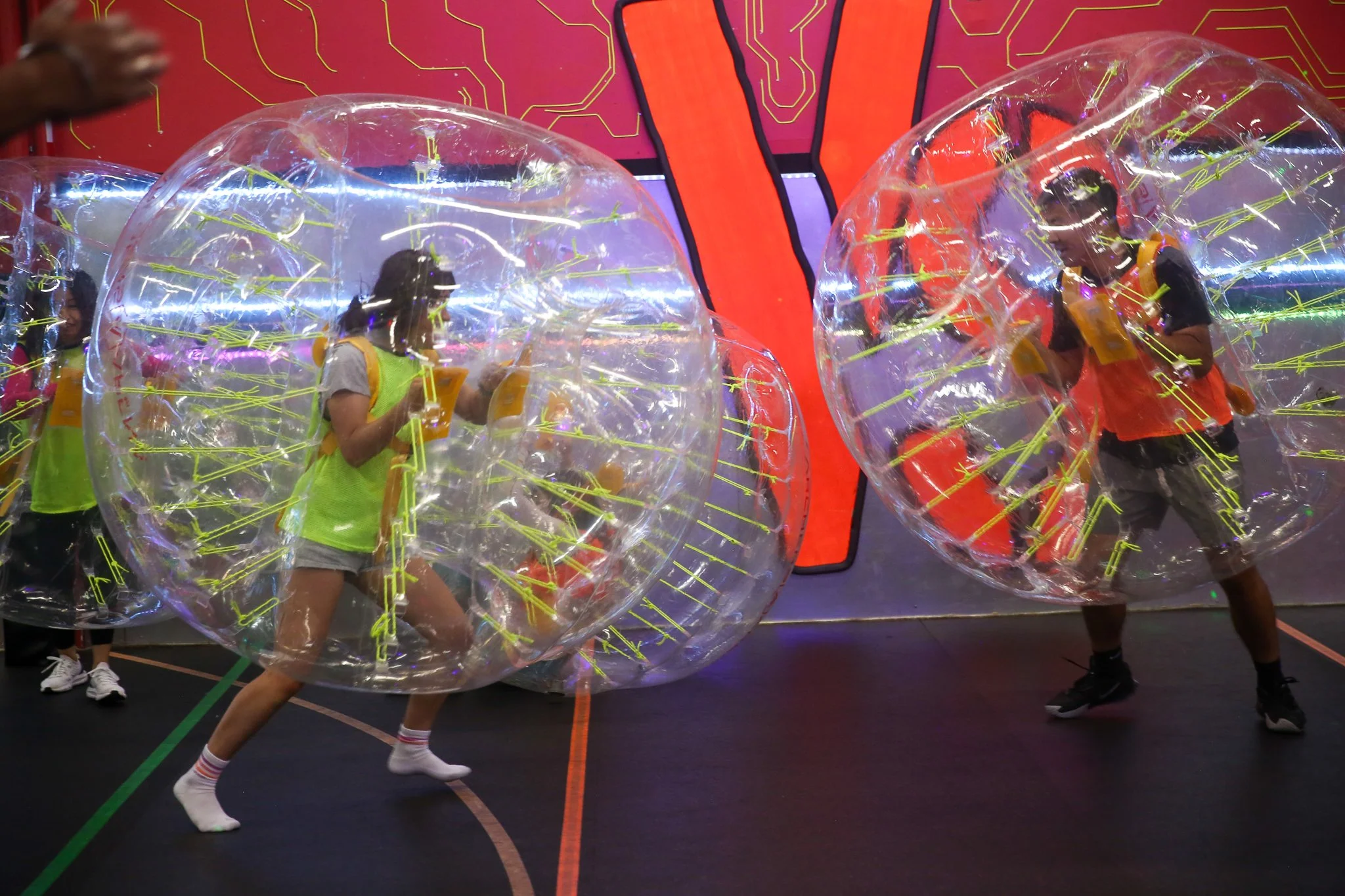 Adults laughing while playing Bubble Soccer indoors in Toronto