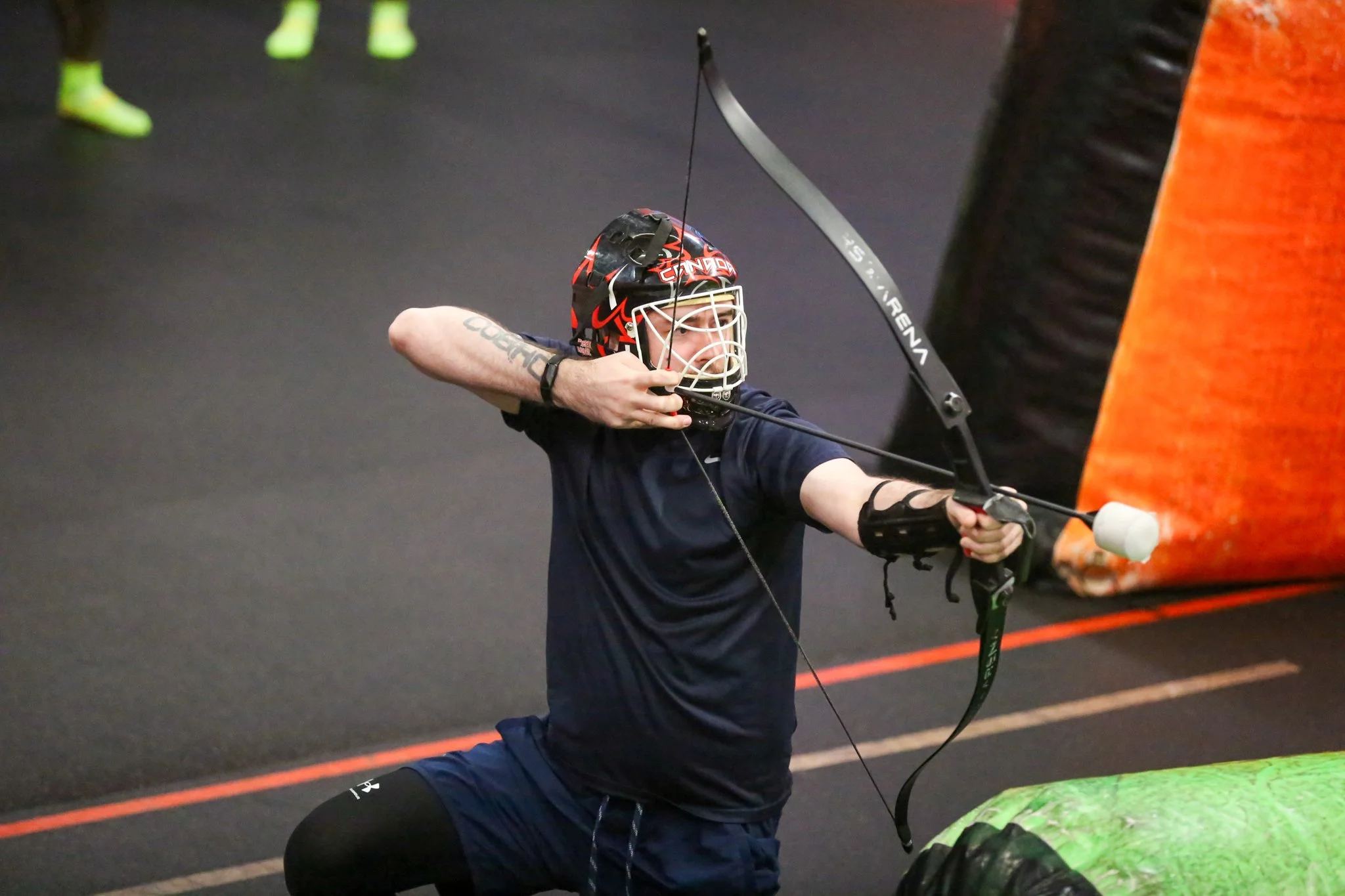 players dodging foam arrows during indoor combat archery game