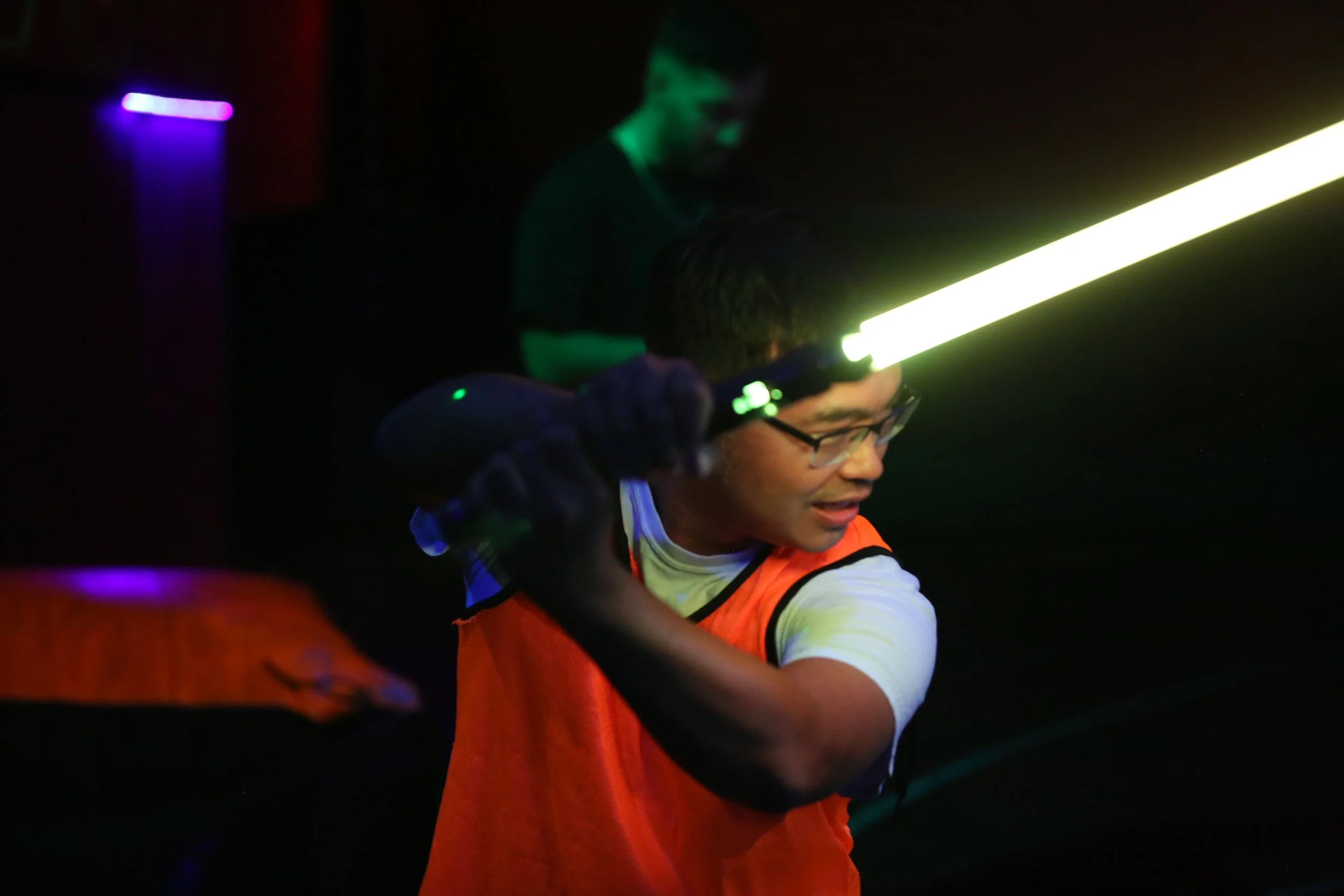 Friends competing in Saber Wars at an indoor Toronto activity venue