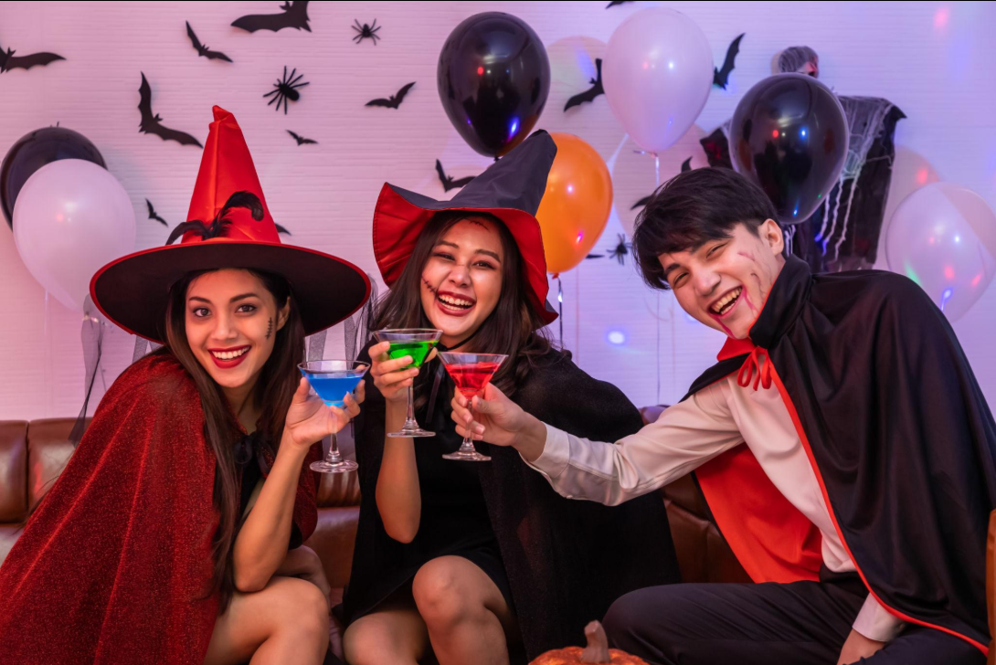 Friends in costumes singing in the karaoke lounge at Archers Arena during a Halloween party in Toronto