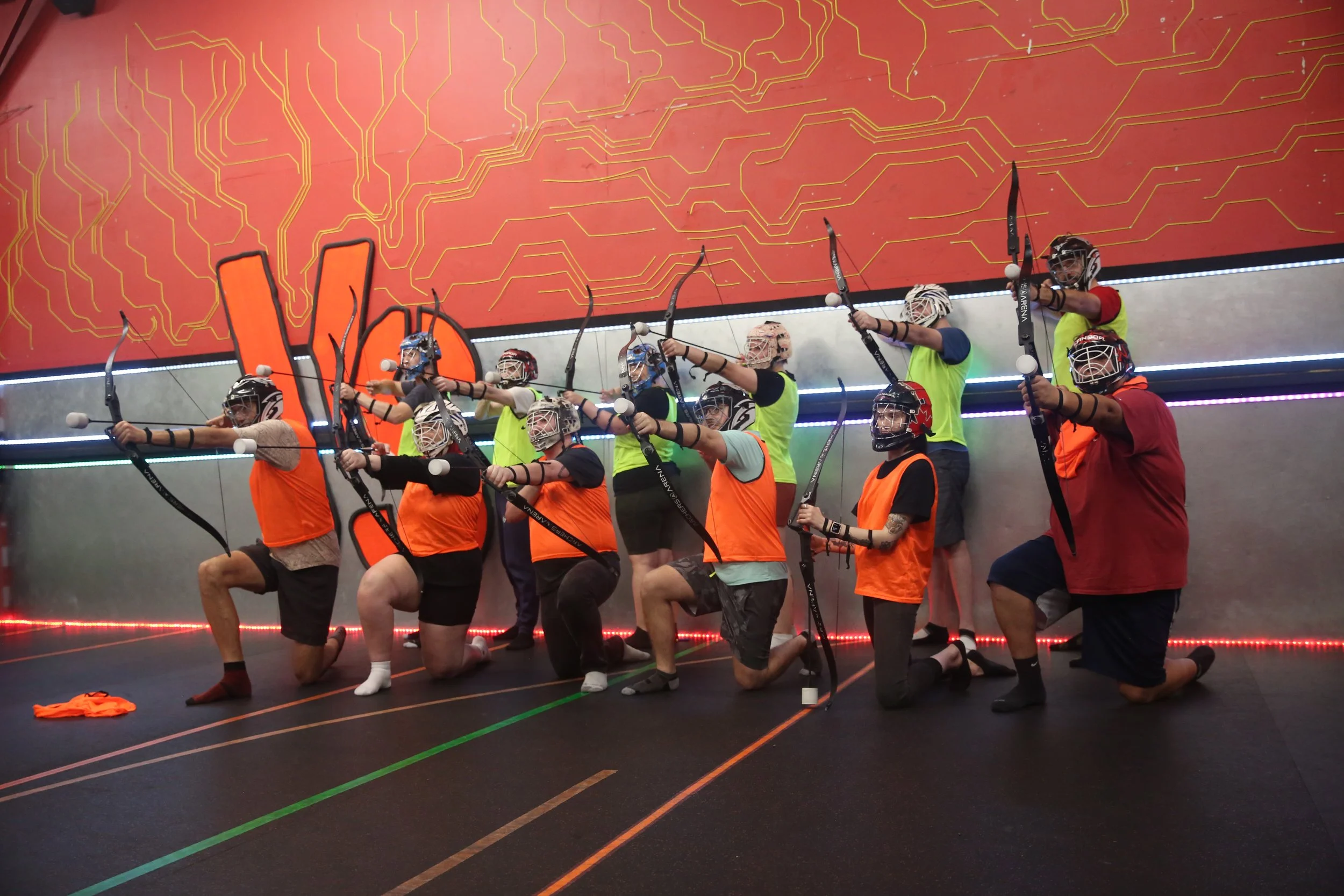 team playing combat archery in indoor Toronto arena with foam arrows and barriers