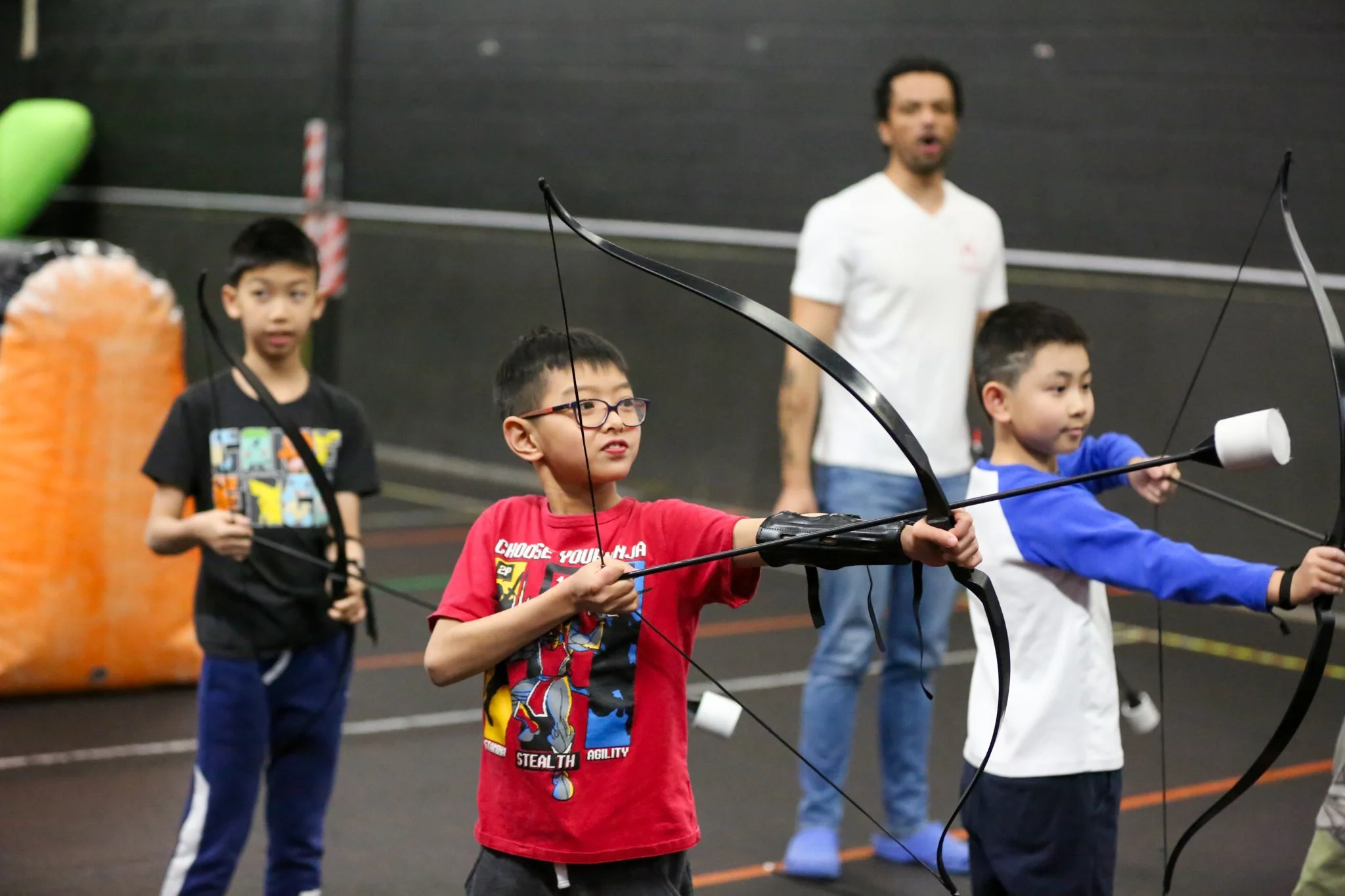 Young archer learning beginner archery with a coach at Archers Arena in Toronto