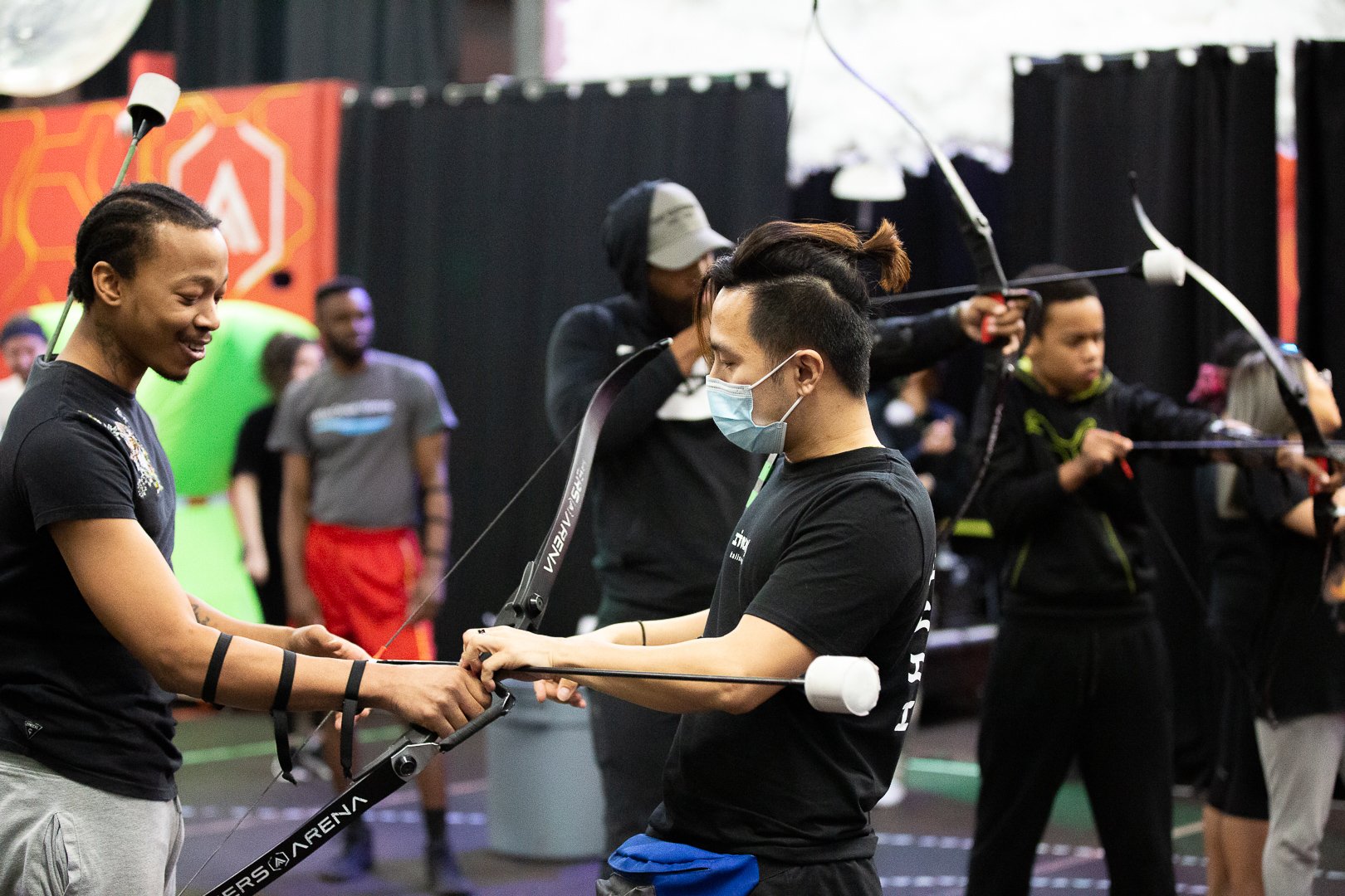 Archery instructor teaching proper shooting form to a beginner at Archers Arena