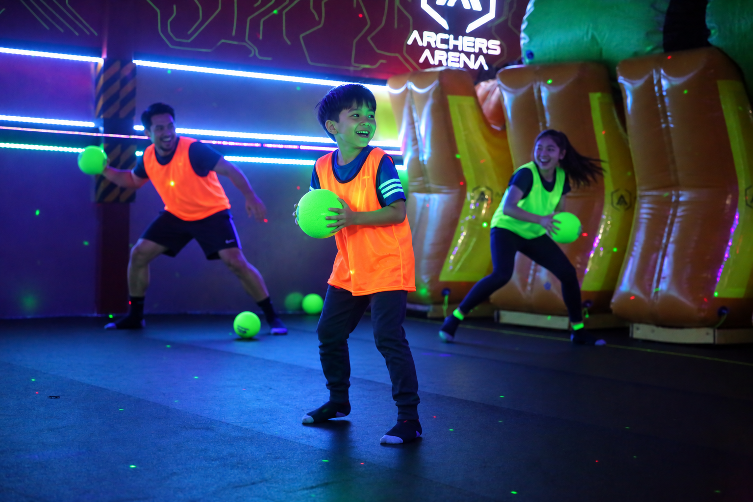 Kids enjoying glowing Blacklight Dodgeball during an indoor family outing in Toronto