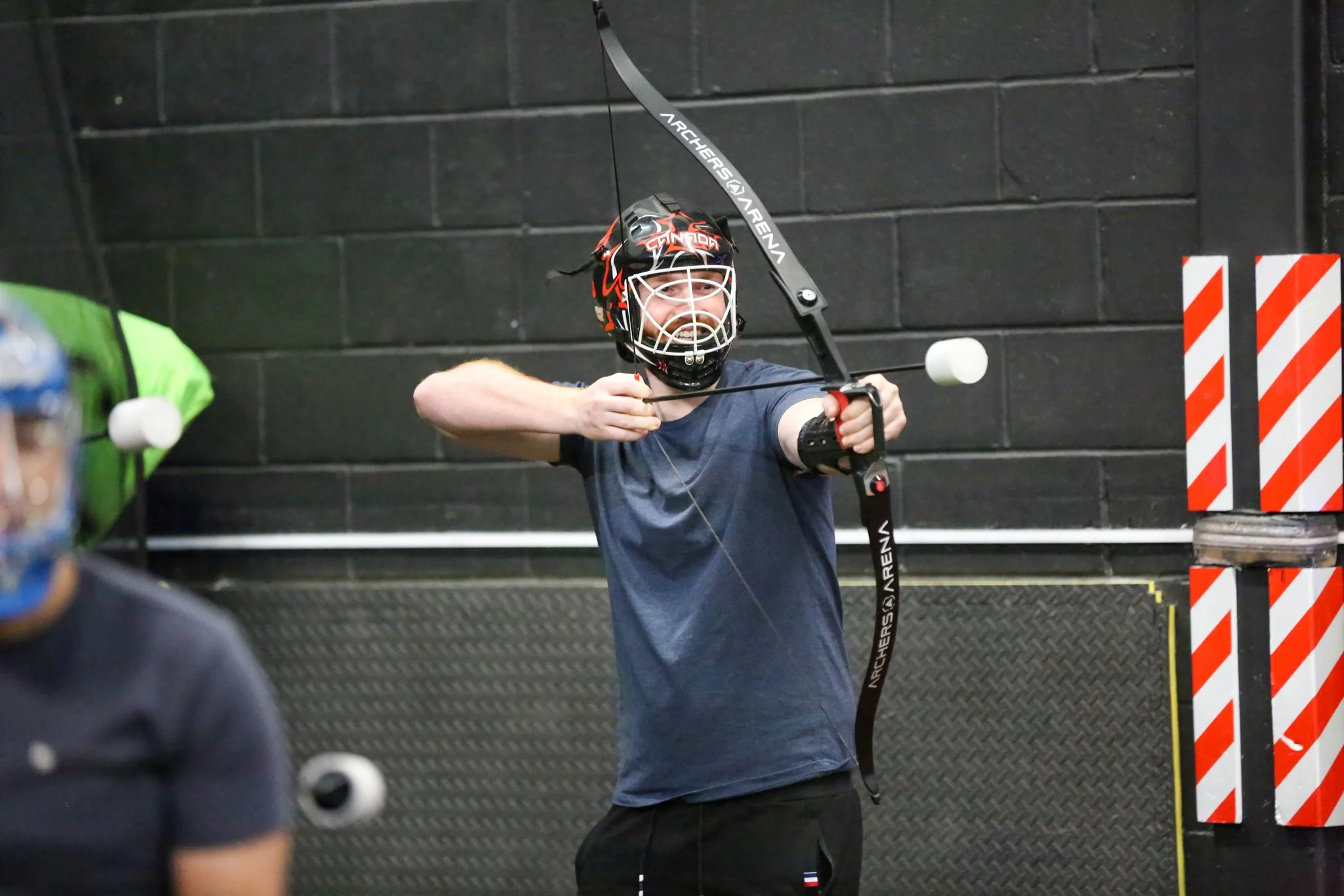 Adults playing combat archery team building activity in Toronto