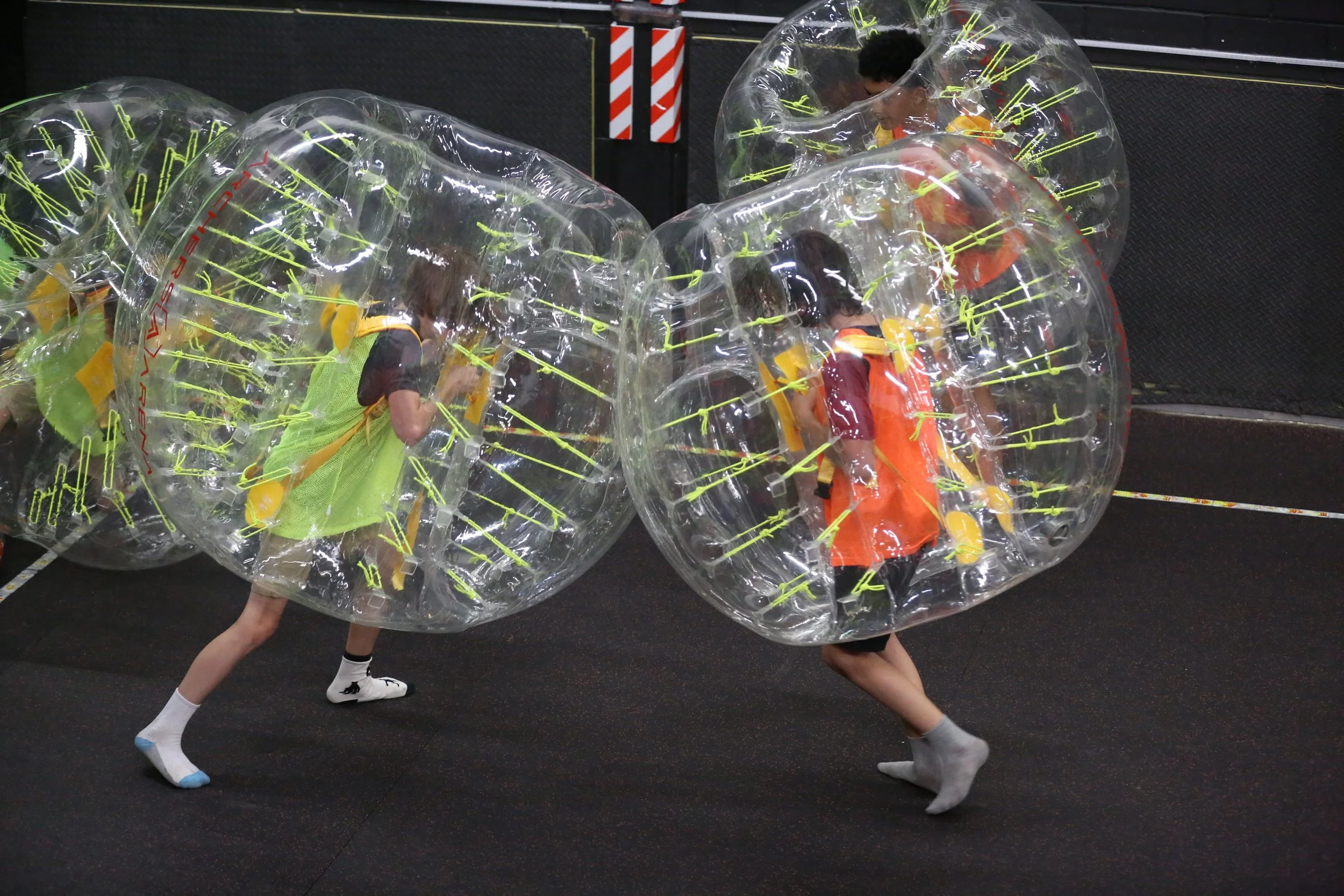 Family laughing while playing bubble soccer indoor Toronto activity