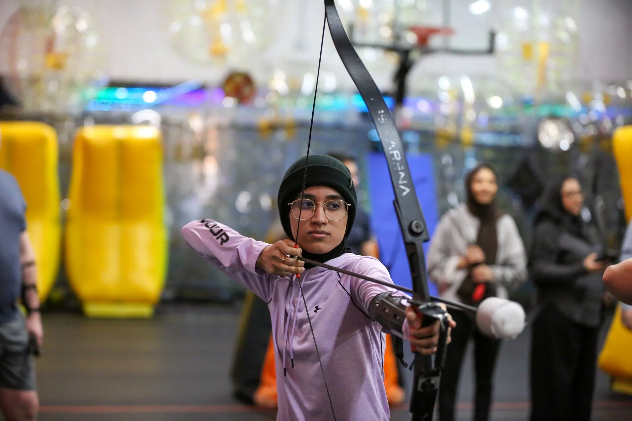 Teenager learning archery and aiming at a target at Archers Arena