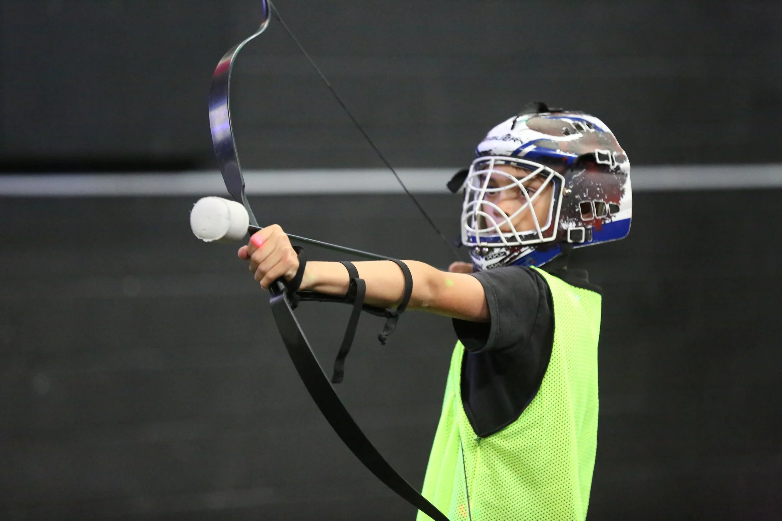 Kids learning beginner archery training in Toronto indoor arena