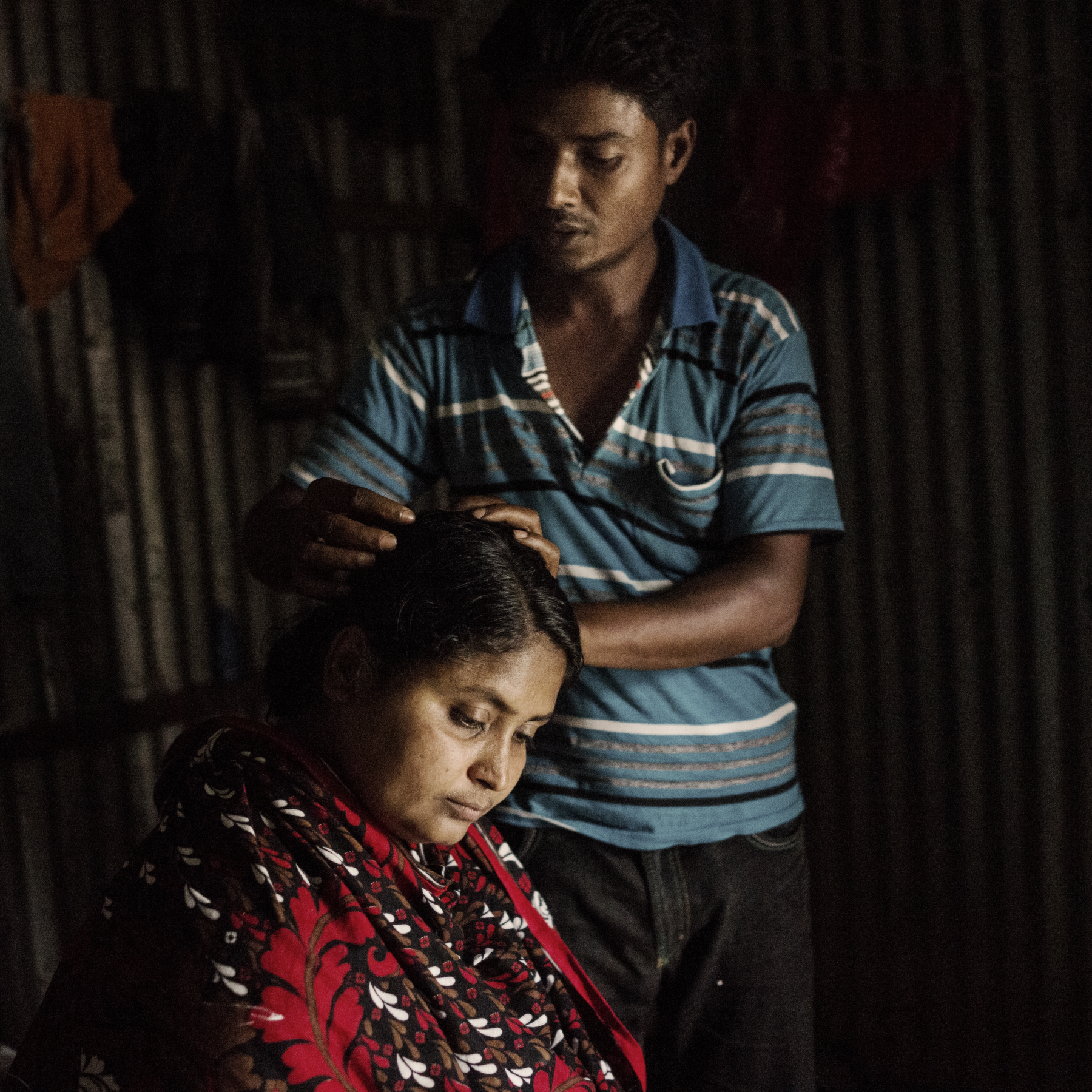 Mominul Islam, husband of Rana Plaza survivor Sharvanu, gently brushes her hair, as he tells the story of finding his wife amongst the chaos.