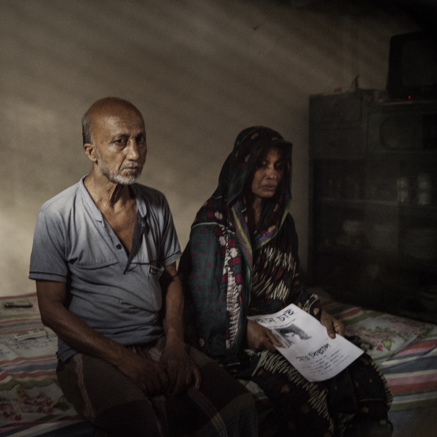  Mosammat Shahana, mother of Mohammad Belal Hossain, holds a photo of her youngest son’s missing notice, as his body was never found after the Rana Plaza collapse.