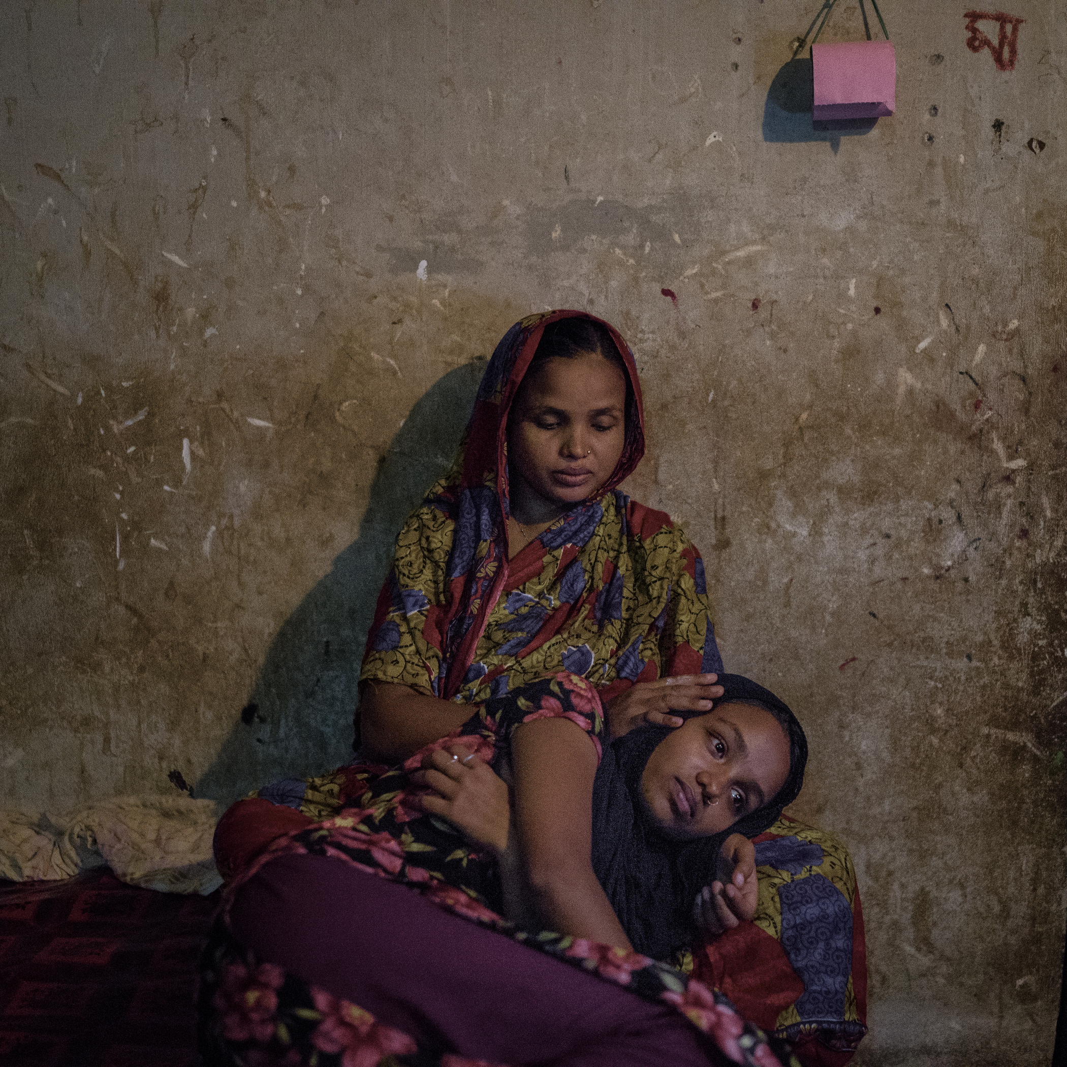 Parvin Begum consoles her daughter Rabeya Khanam, who survived the Rana Plaza collapse but suffers from emotional, mental, and physical trauma 