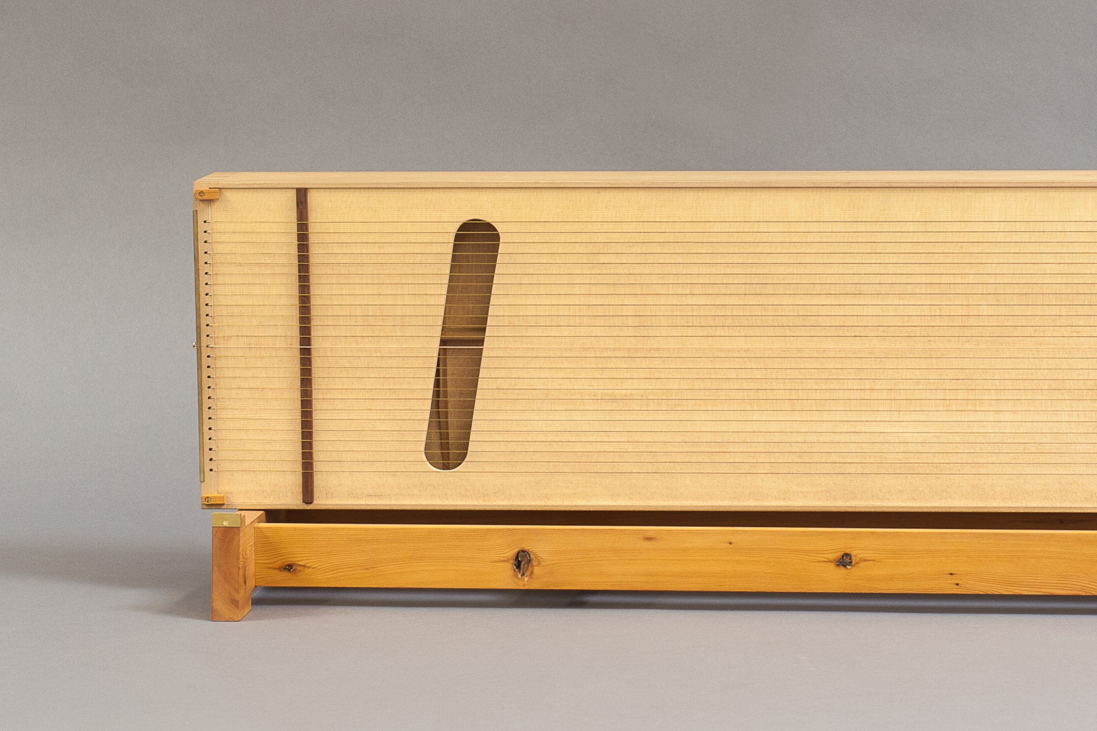 The sound hole design, coupled with the sympathetic strings, creates a resonance and reverberation with the thirteen main strings on top. 
