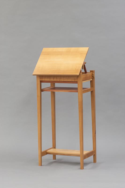 Mechanism tilt forwards. Good for drafting or a music stand.