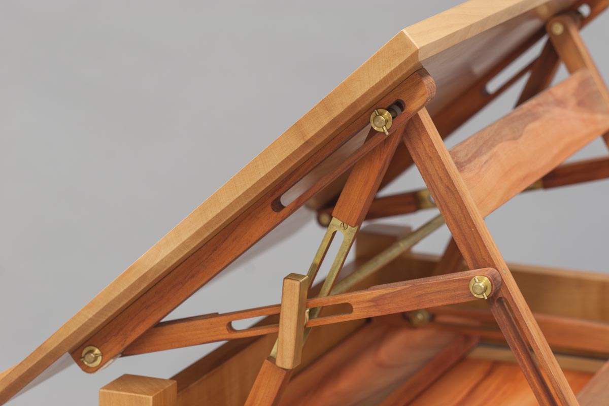 The handmade adjustable desktop mechanism, an original design, is made in Peroba Rosa and brass. Two adjustment points raise/lower or tilt the top.