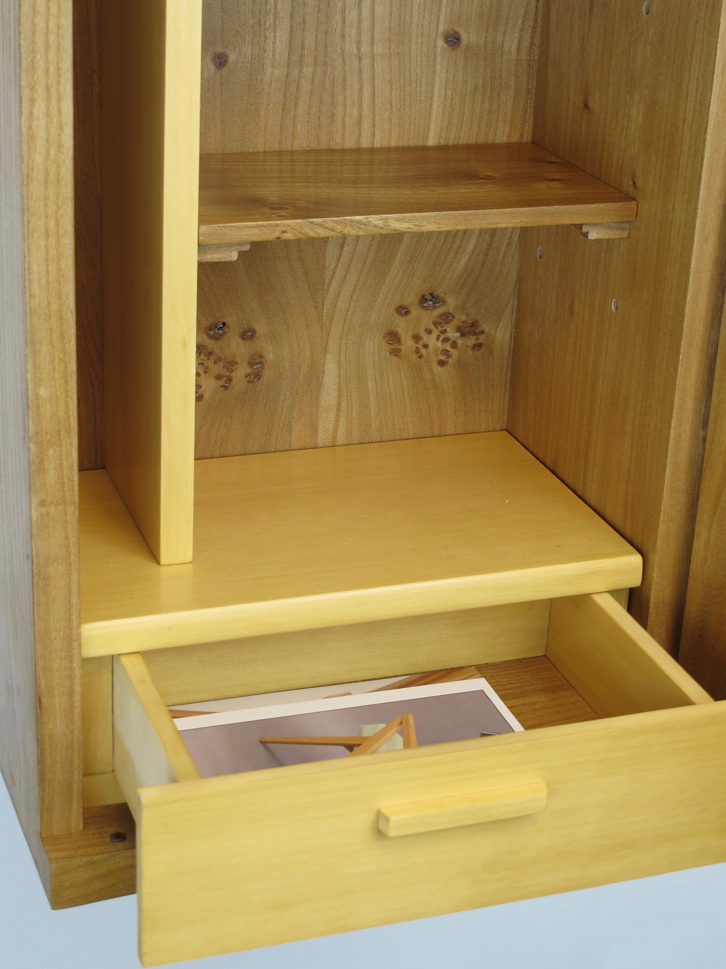 The interior of clear, fine grained Alaskan yellow cedar provides a compliment to the exterior of coarser grained elm. The drawer face was mortised and tenoned, to allow an overlay of the drawer box.