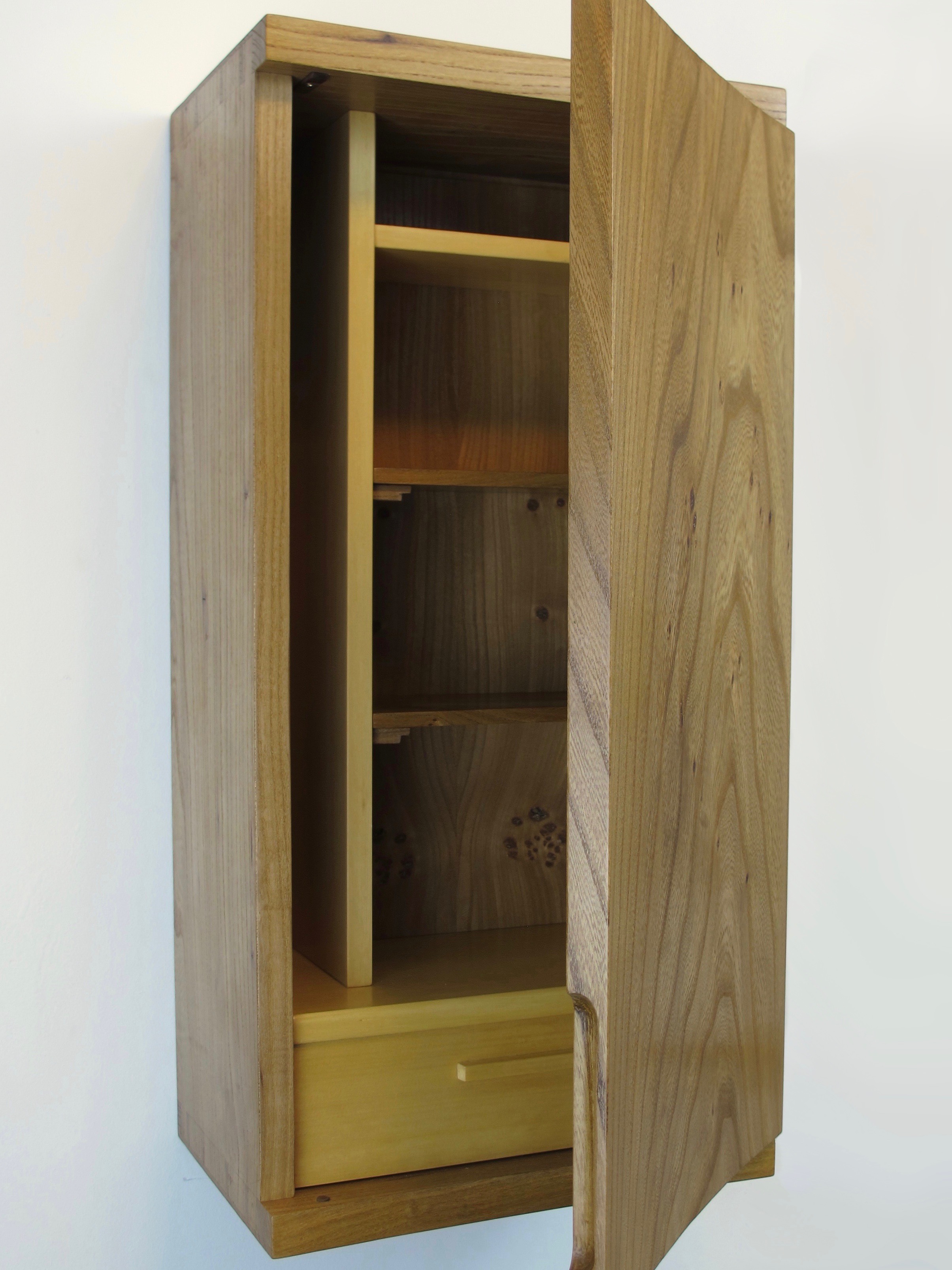 The door is convex, having been coopered by hand from a single piece. The profile of the top and bottom of the carcass match this curve.