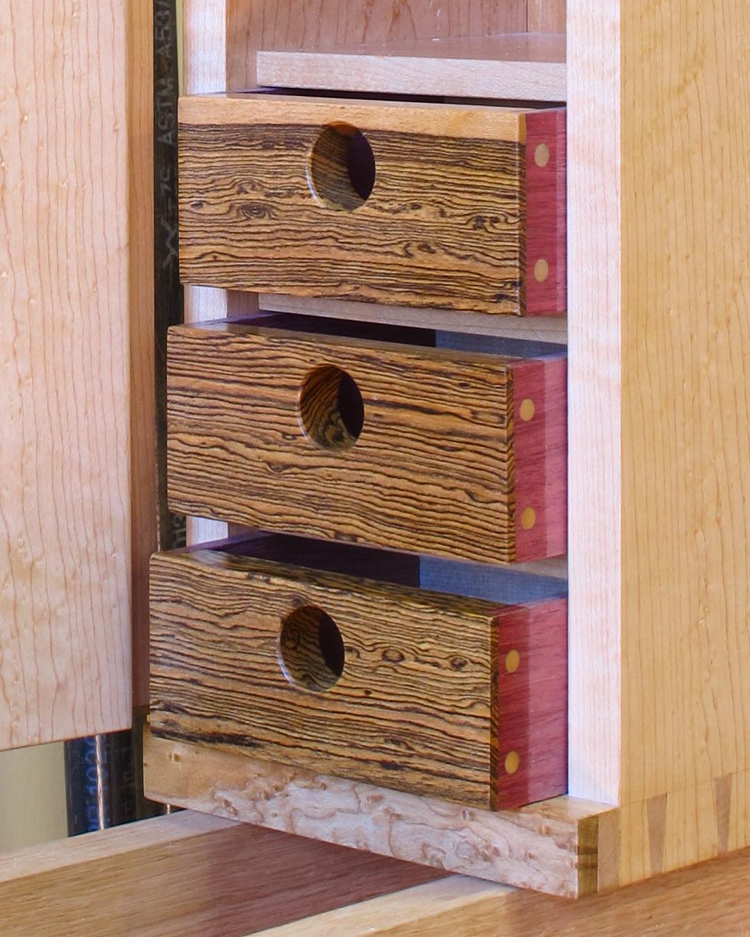 The drawers are unique, with bocote fronts and purpleheart sides, with a doweled lap joint.