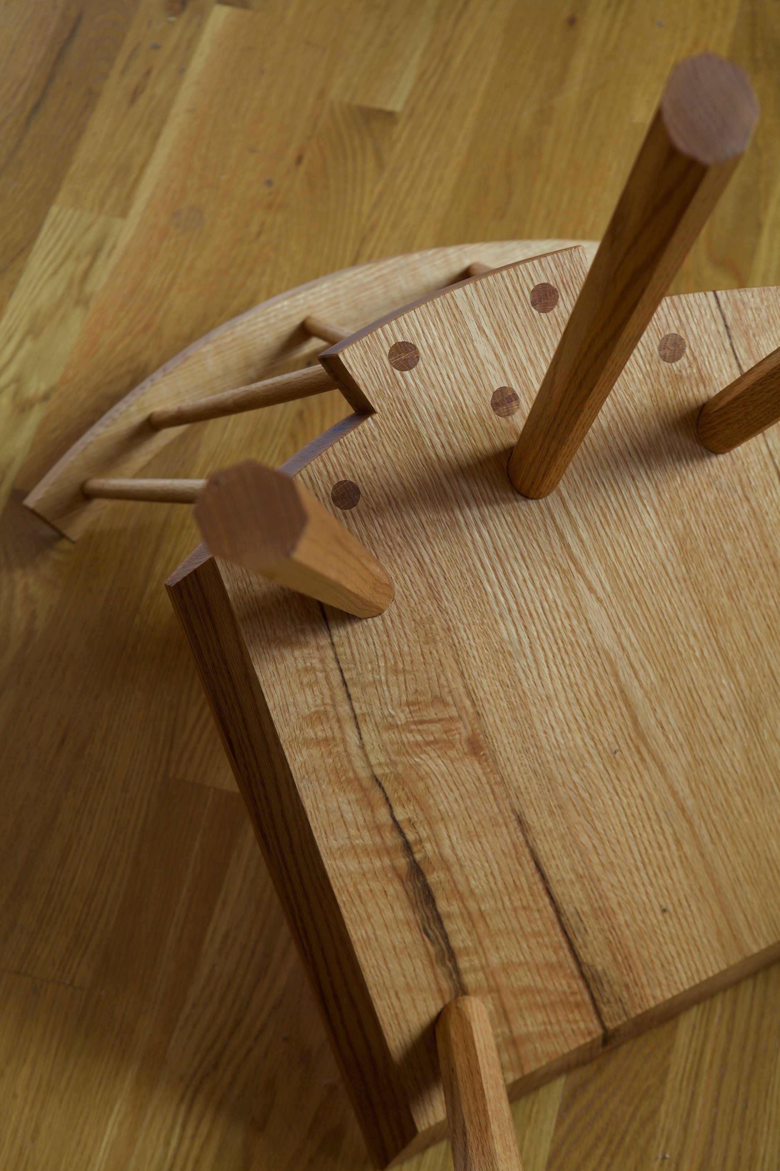 Every tenon in this design is a through tenon that is backwedged. The spindles that support the crest are wedged from beneath the seat and through the top of the crest. The legs are tapered tenons and backwedged through the seat.