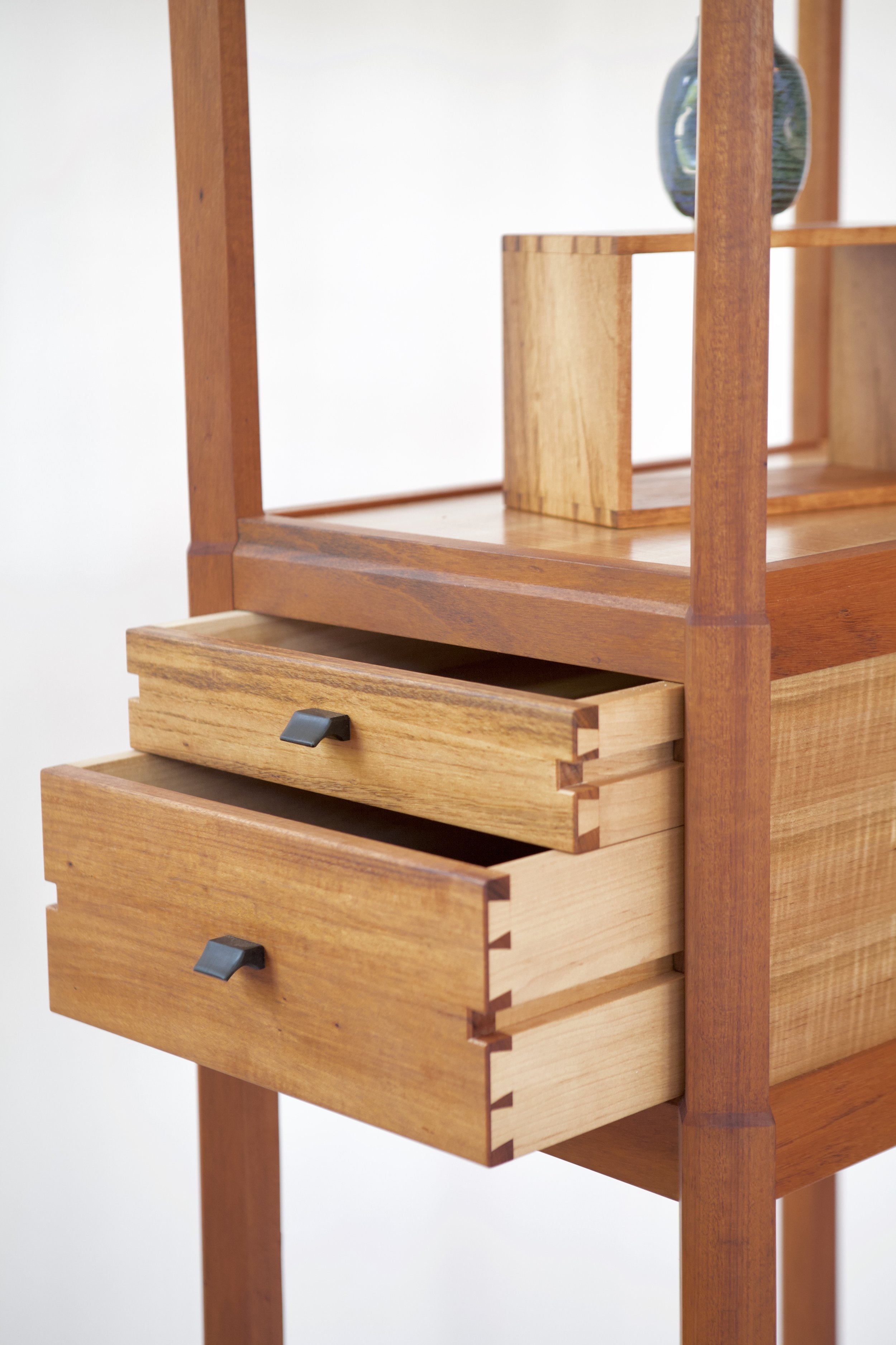 The side-hung drawers require a particular dovetail layout and a precision in fabrication. The pulls were carved by hand with a knife from African blackwood.