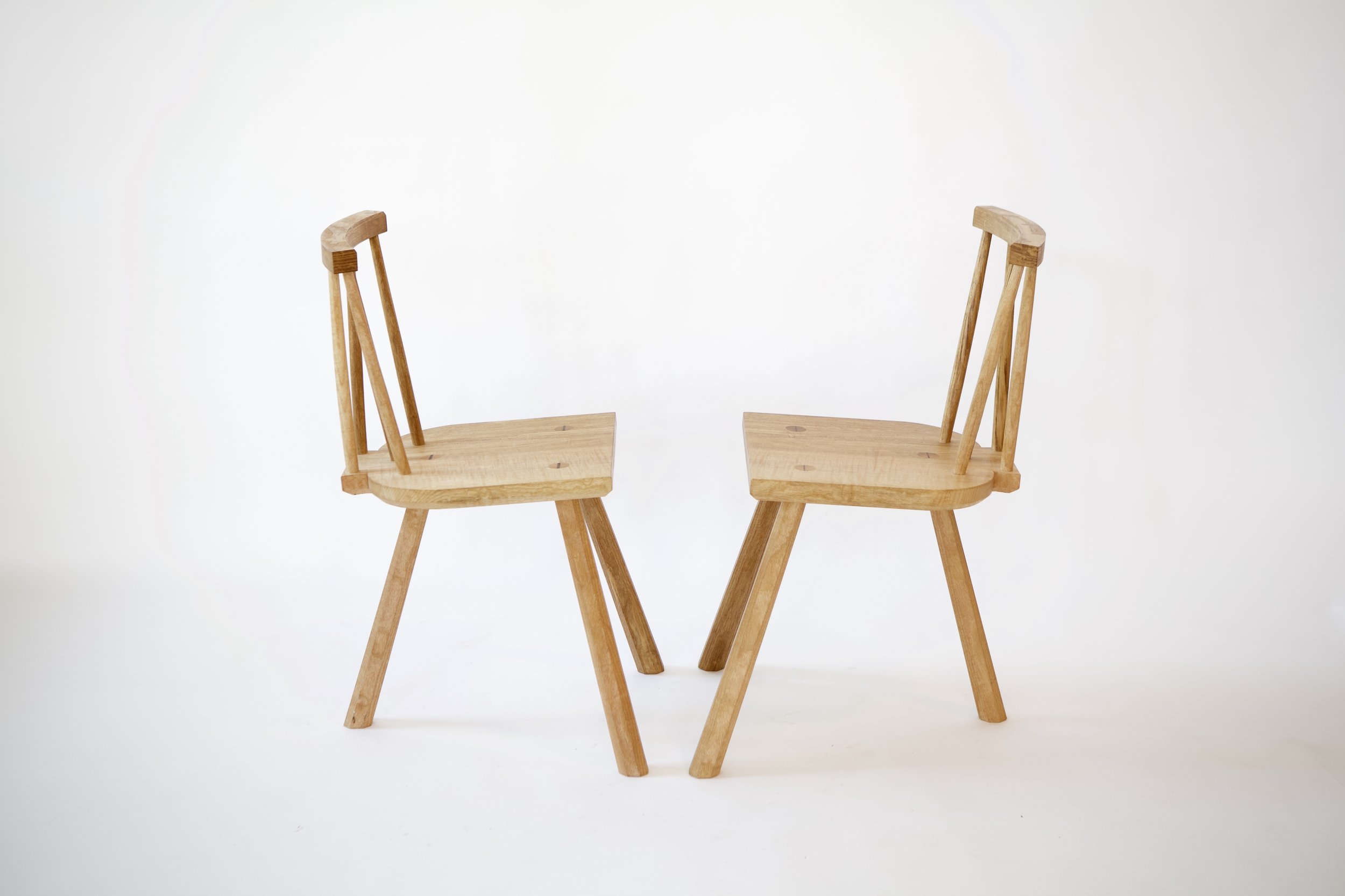 These chairs were based on a historic example from England, sold at auction. The elaborate braced backrest and three tapered legs both came from that original design, along with the overall small dimensions.