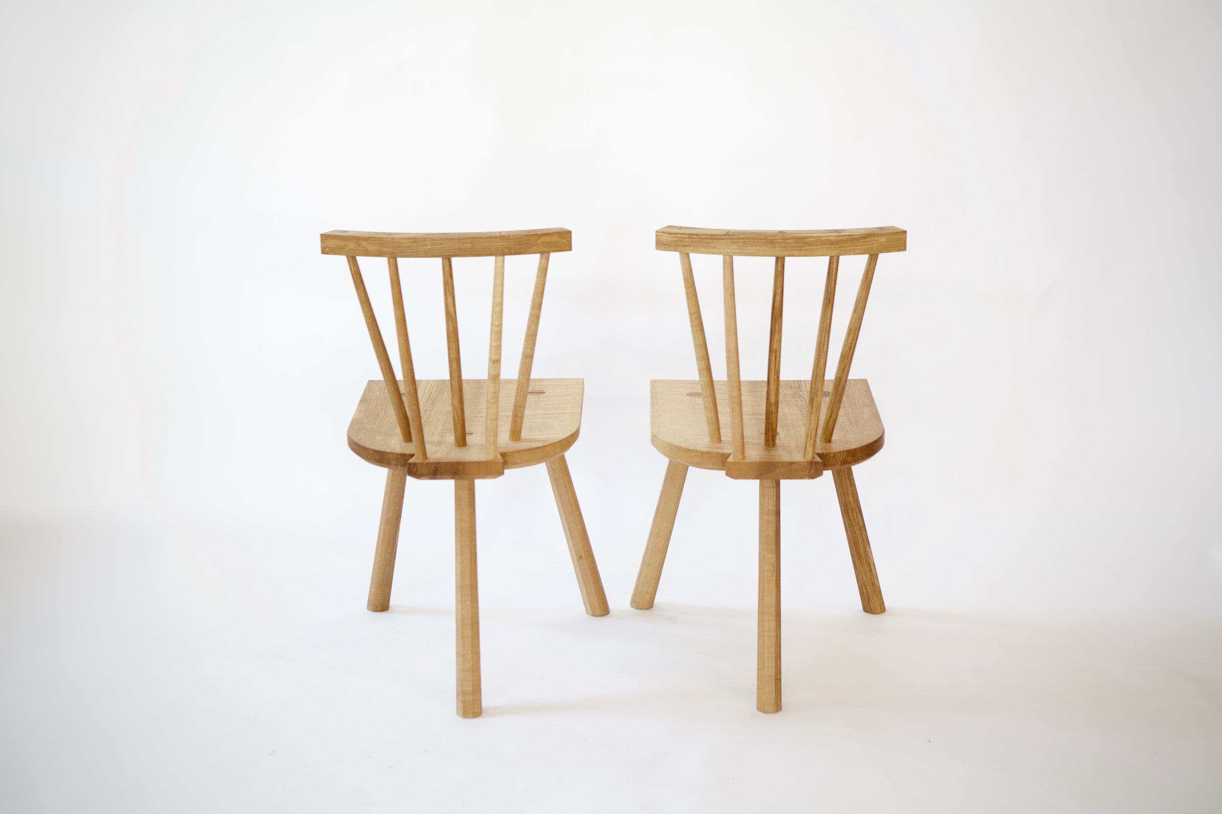 The five spindles supporting the back are color-matched to the figure in the seat, giving an asymmetric coloration in the chairs I find appealing.