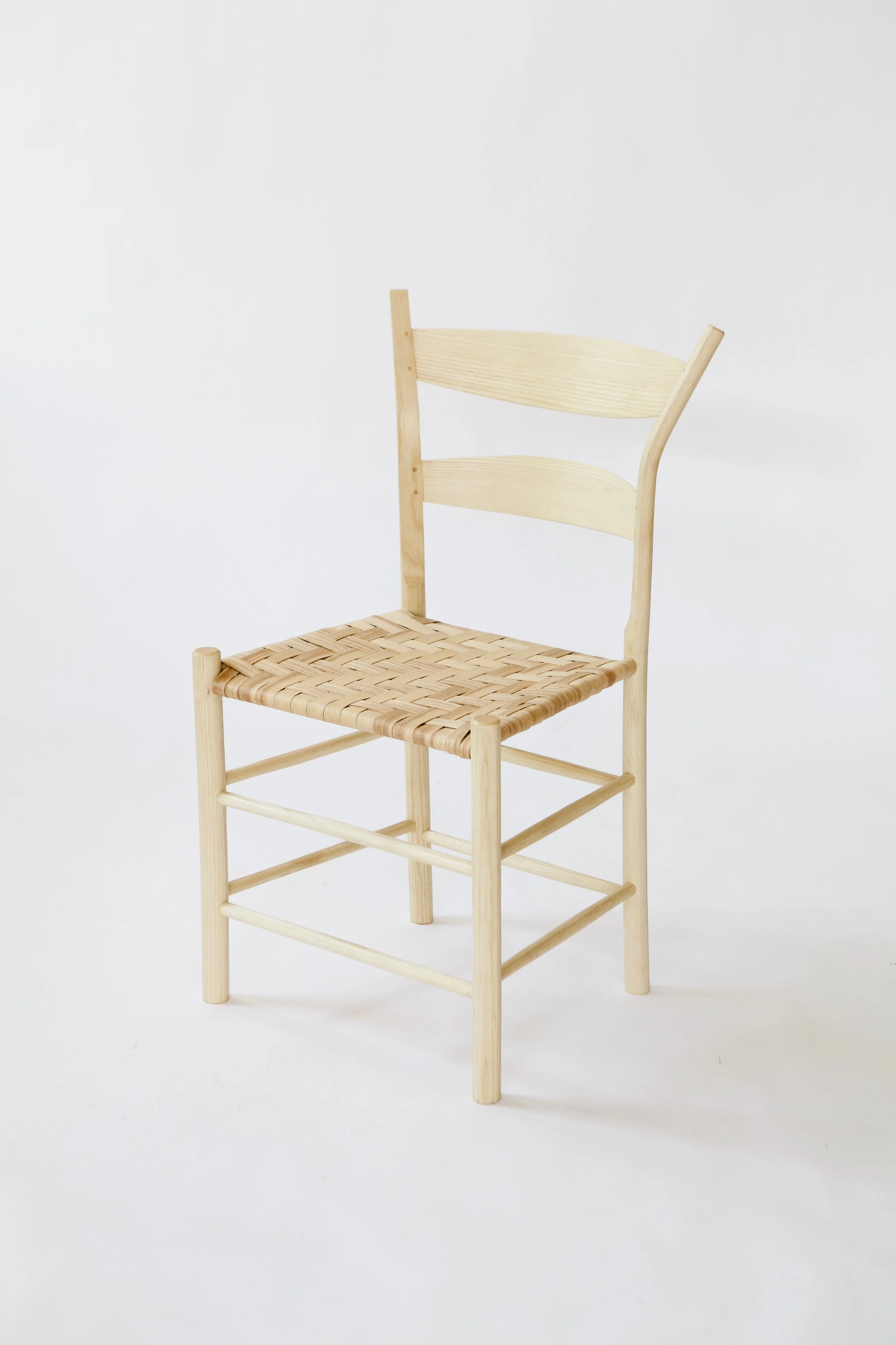  This chair design is based on Jennie Alexander’s famous post-and-rung chairs, with some variations in geometry and scale. The back posts are splayed further outwards for a deeper back geometry, and the seat height is lowered for a different seating,