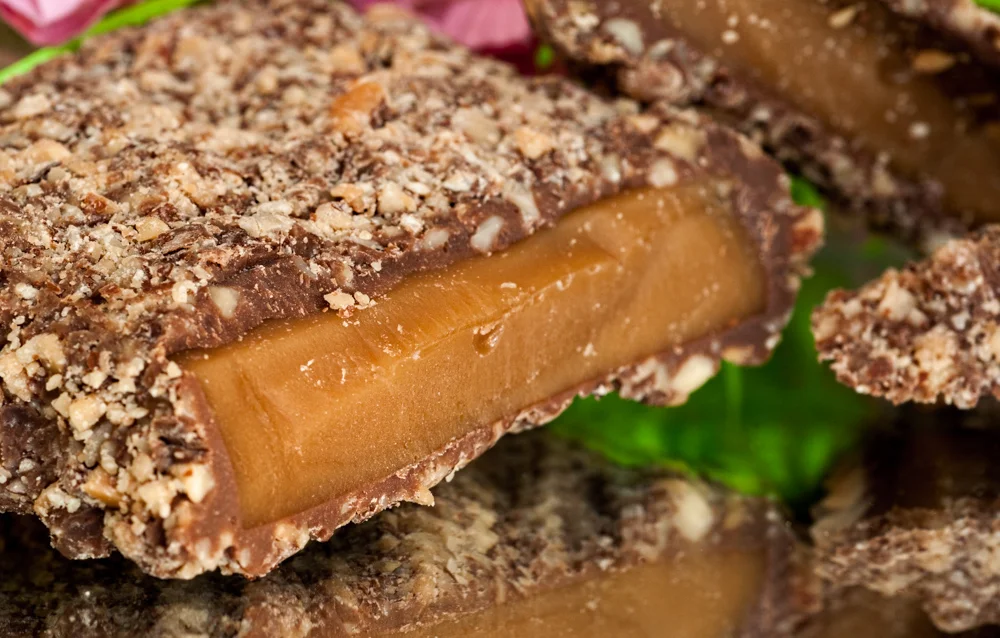Chocolate-covered English toffee with a cut piece showing its center
