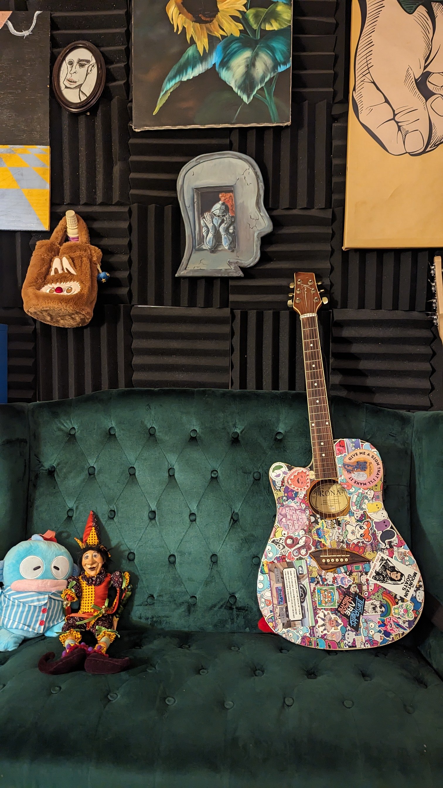 TheyLoveThem LLC's office includes a foam-padded wall (for sound absorption and extra privacy), instruments to play, stim toys, soft stuffed animals (all pictured), and a green couch to sit on.
