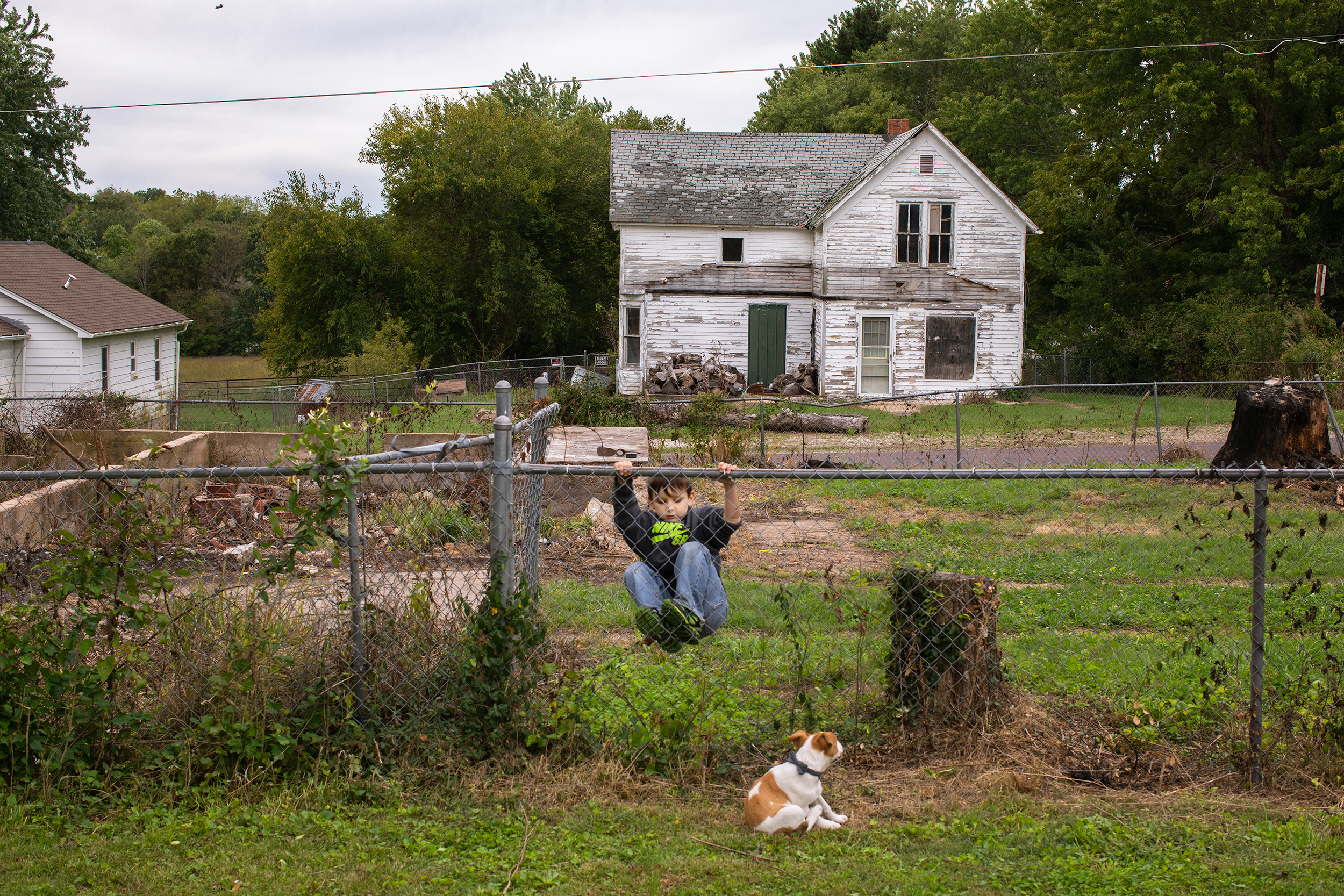  Brenda’s grandson, Jonathan, 6, and their family puppy play in the yard in Mountain Grove, Mo. 