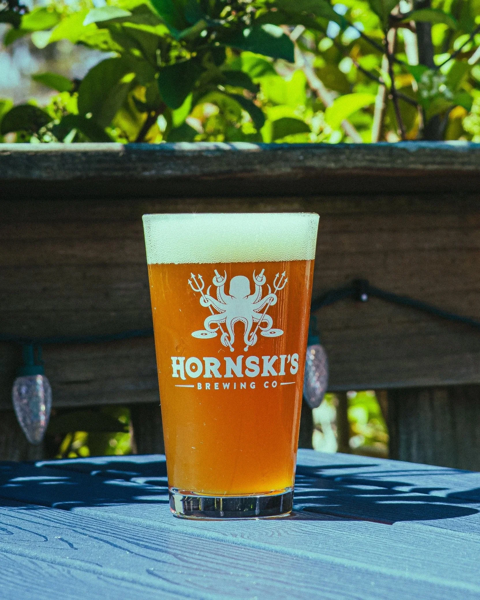 Beer in a glass outside on a patio.