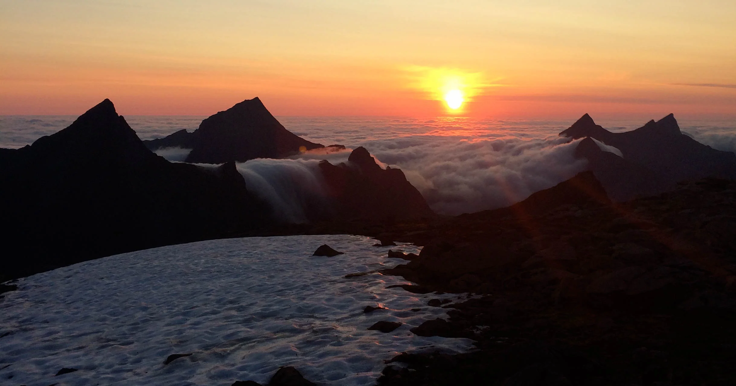 Midnatt og fortsatt sol ved fjellet Munken. Havskodda siger inn over fjellene. ©Foto: Bjørnar Eidsmo
