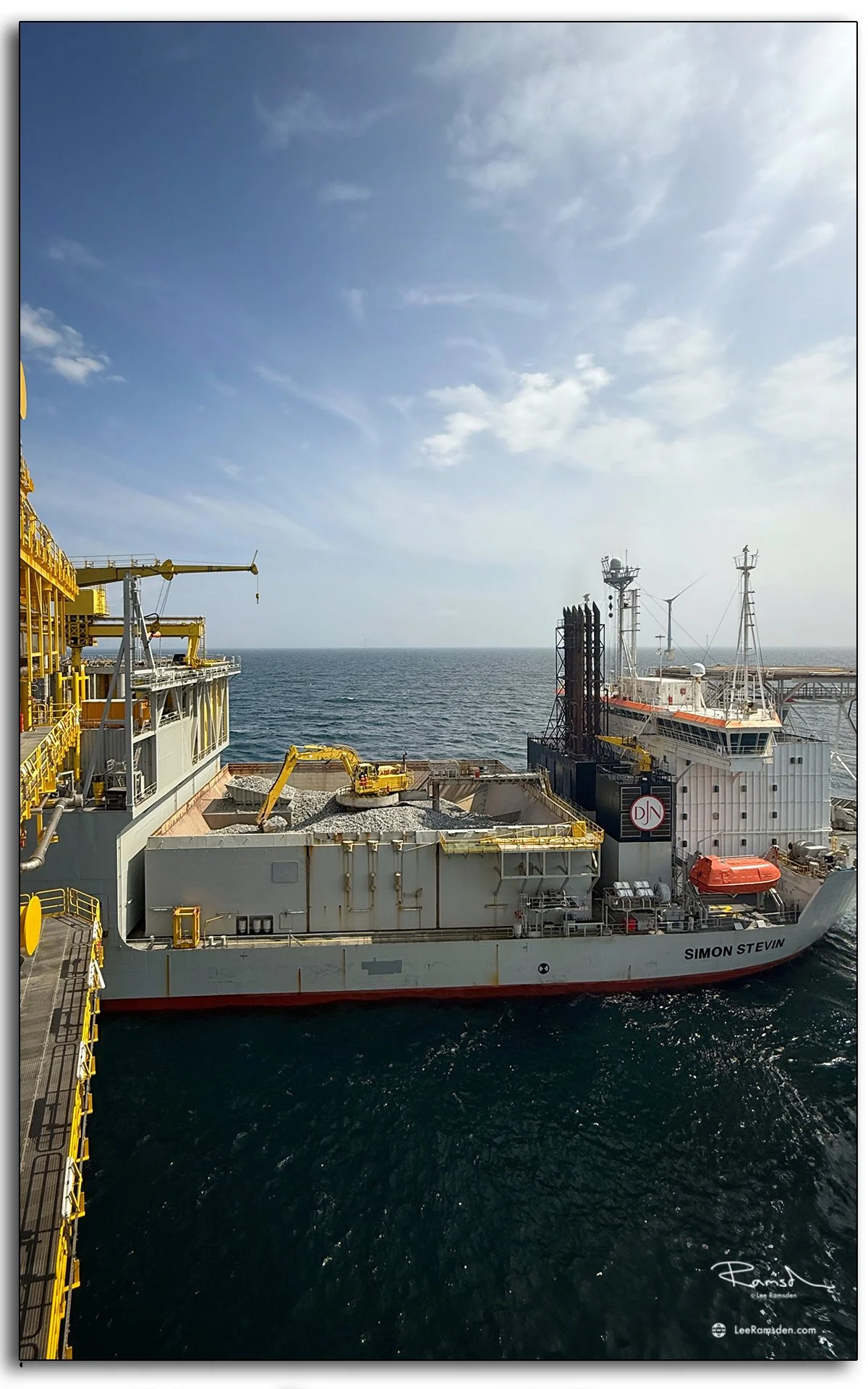 Rock dumping offshore with the Simon Stevin vessel – precision engineering, seabed stability, and a digger at sea in the North Sea wind farm field.