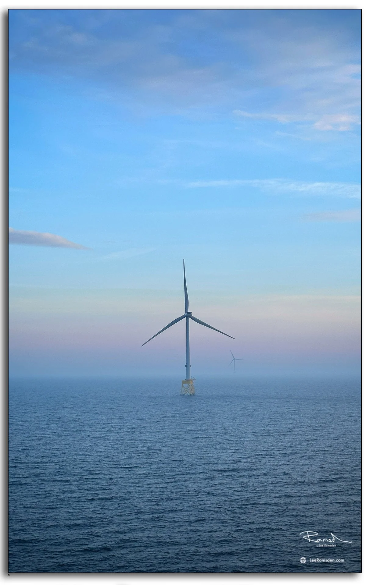 North Sea wind turbine framed by pastel skies and calm waters, a striking image of offshore renewables.