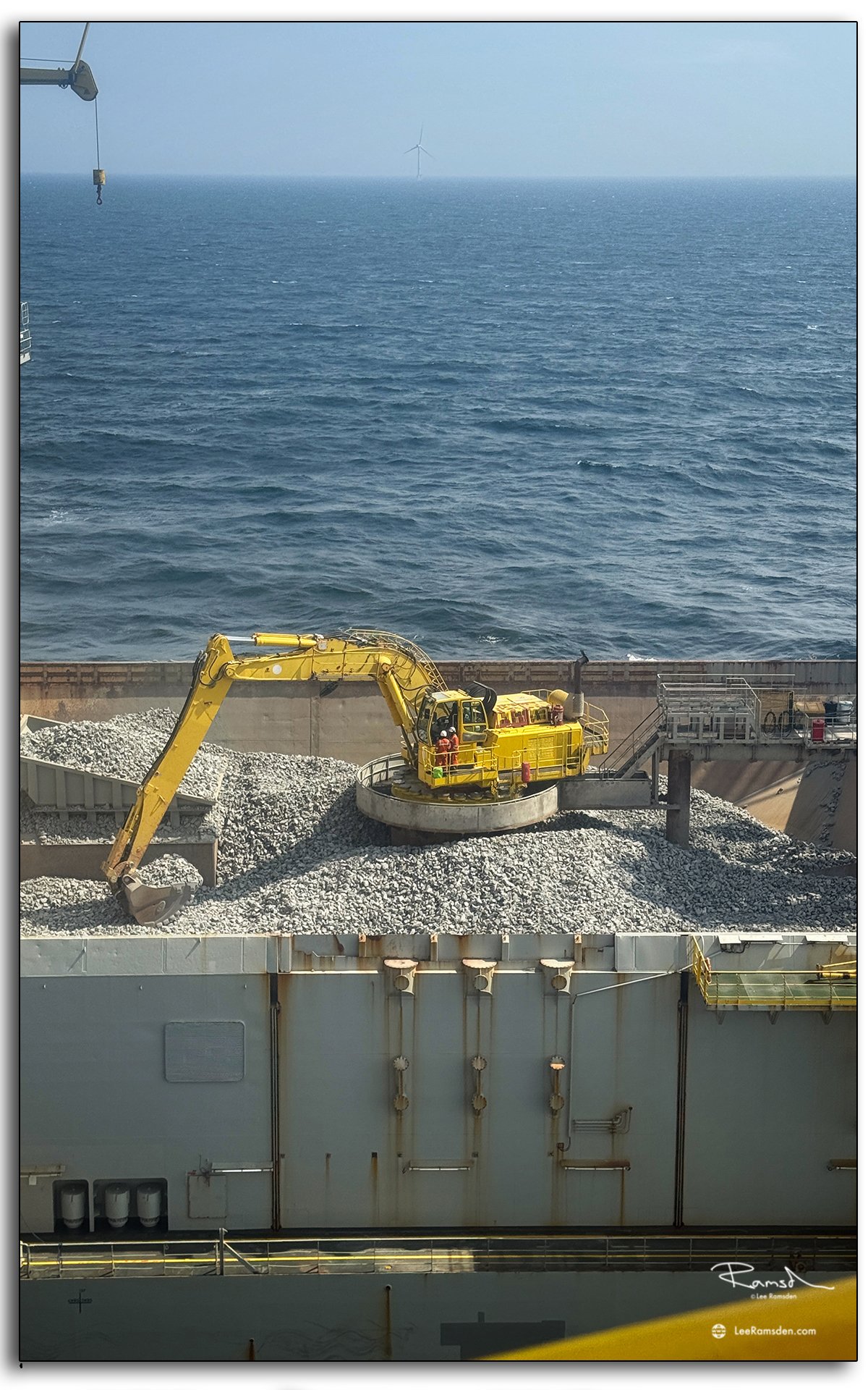 Close-up of excavator on Simon Stevin ship moving graded rock offshore