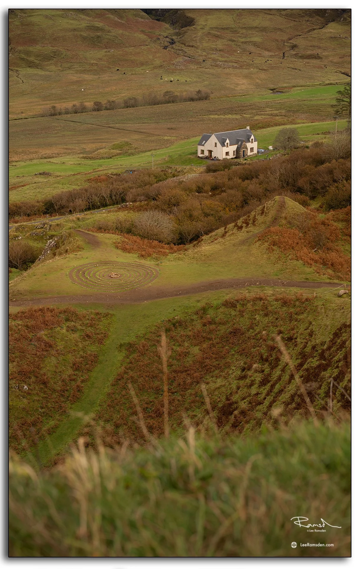 iew over the Fairy Glen on the Isle of Skye, featuring a stone spiral and a lone cottage nestled among rolling green hills