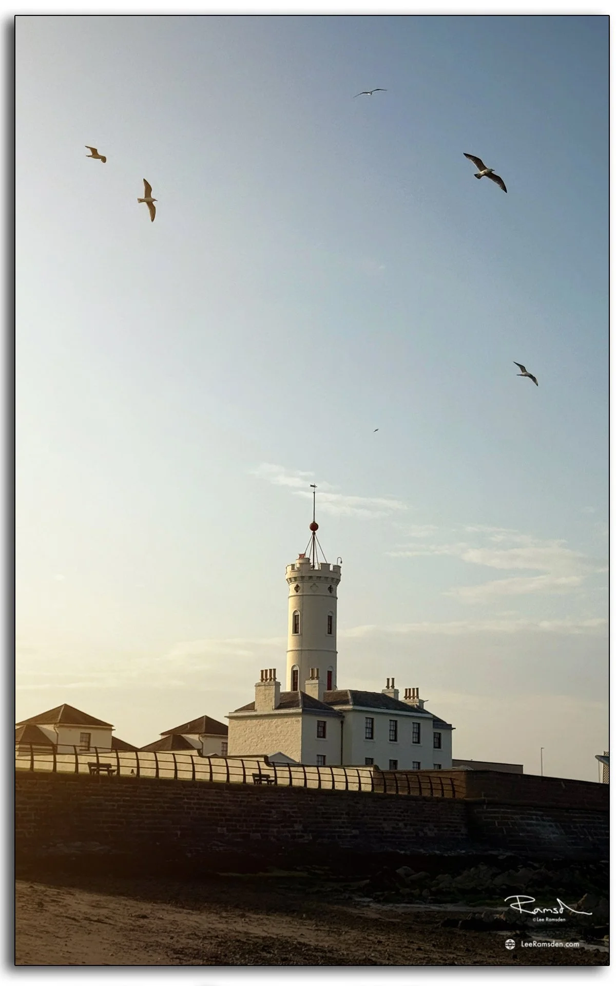 Arbroath Signal Tower lighthouse framed by seagulls in flight.