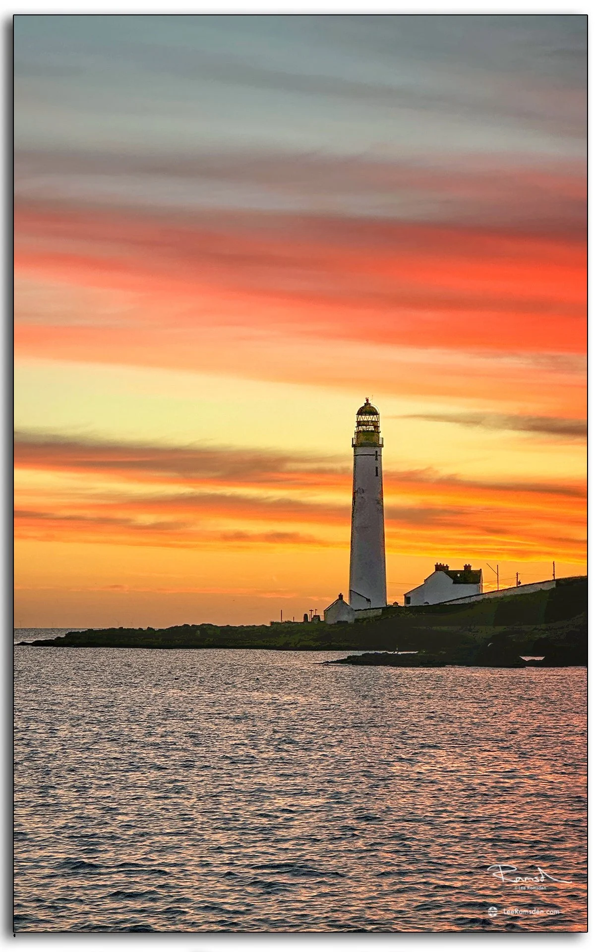 Scurdie Ness Lighthouse glowing at sunset with orange sky over Montrose