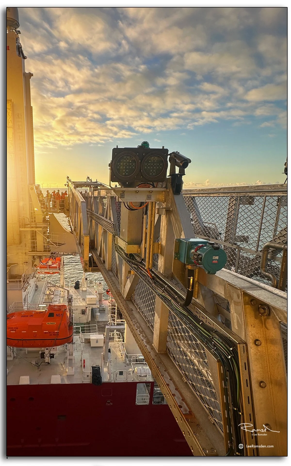 Side view of offshore Walk-to-Work bridge extended to platform, photographed at sunrise.