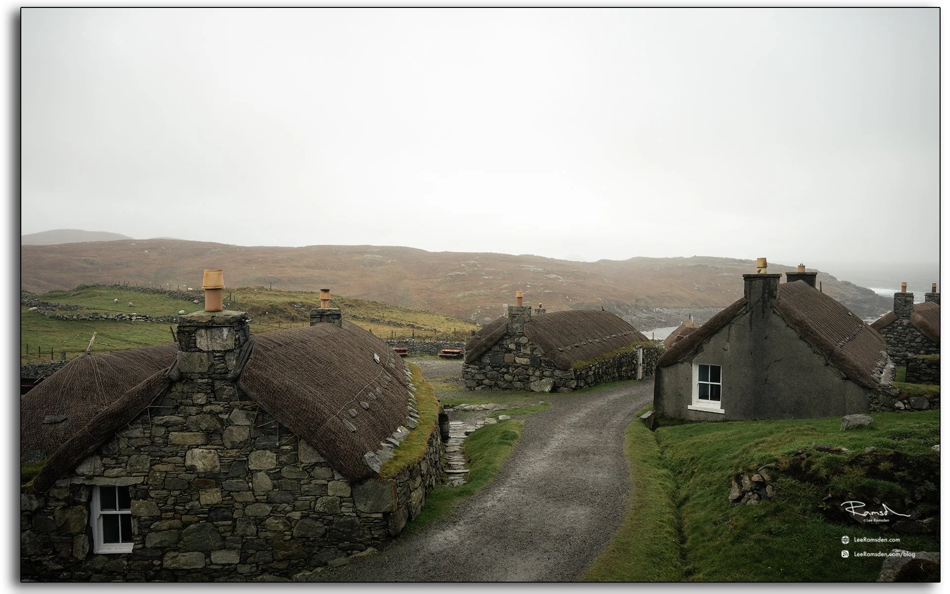Restored blackhouse village at Gearrannan on the Isle of Lewis, Scotland, featuring traditional stone cottages with thatched roofs overlooking the rugged coastline