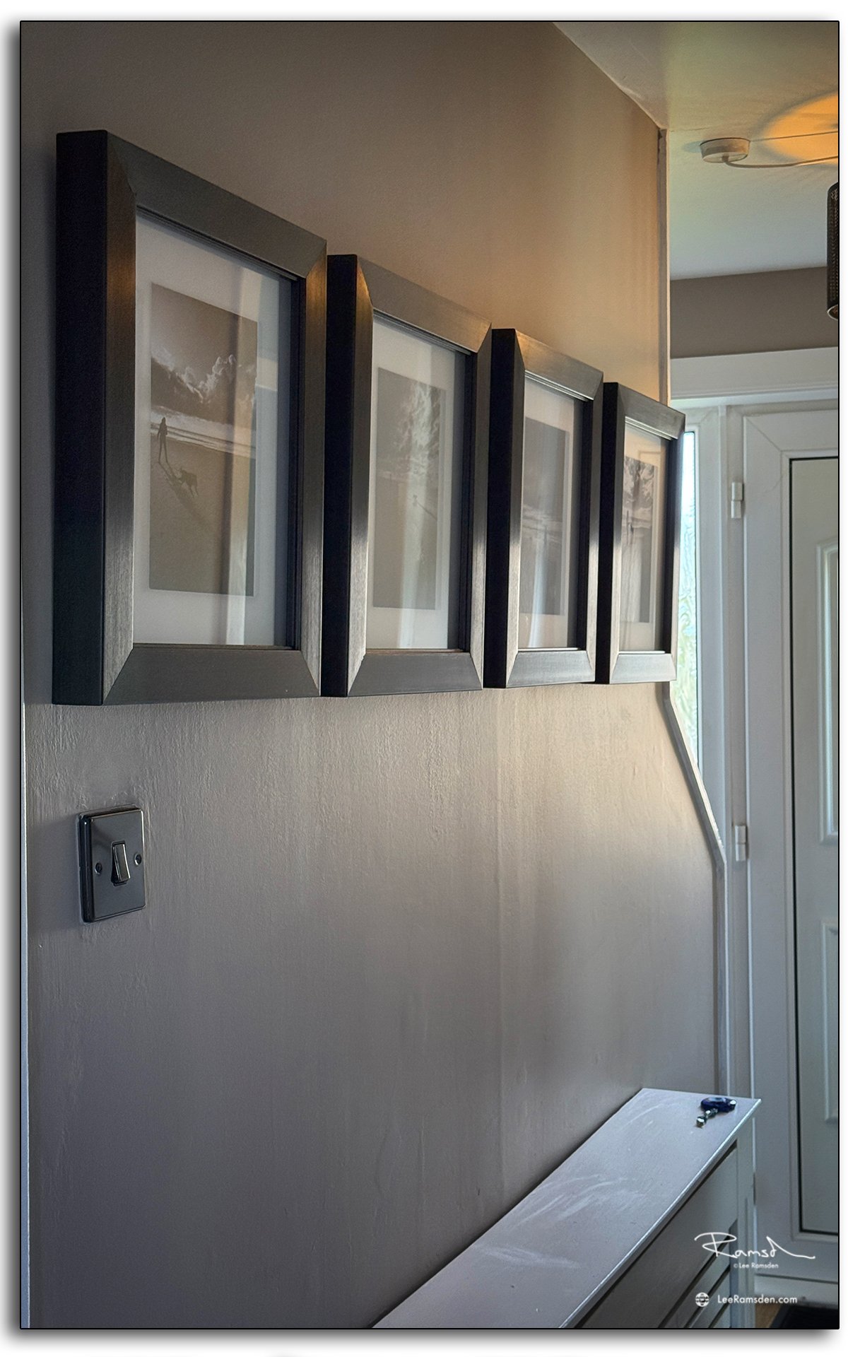 A series of framed photographs hung on a wall, each in a Loxley Colour frame with clean matting and rich tones.