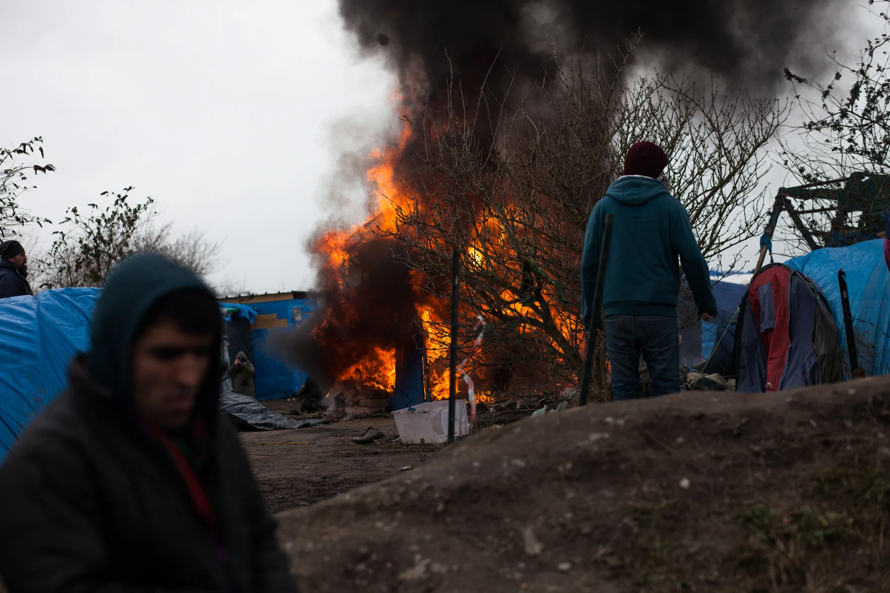Des migrants mettent feu à certaines habitations avant qu'elles ne soient détruites par les forces de l'ordre. L'Humanité - 4.03.16